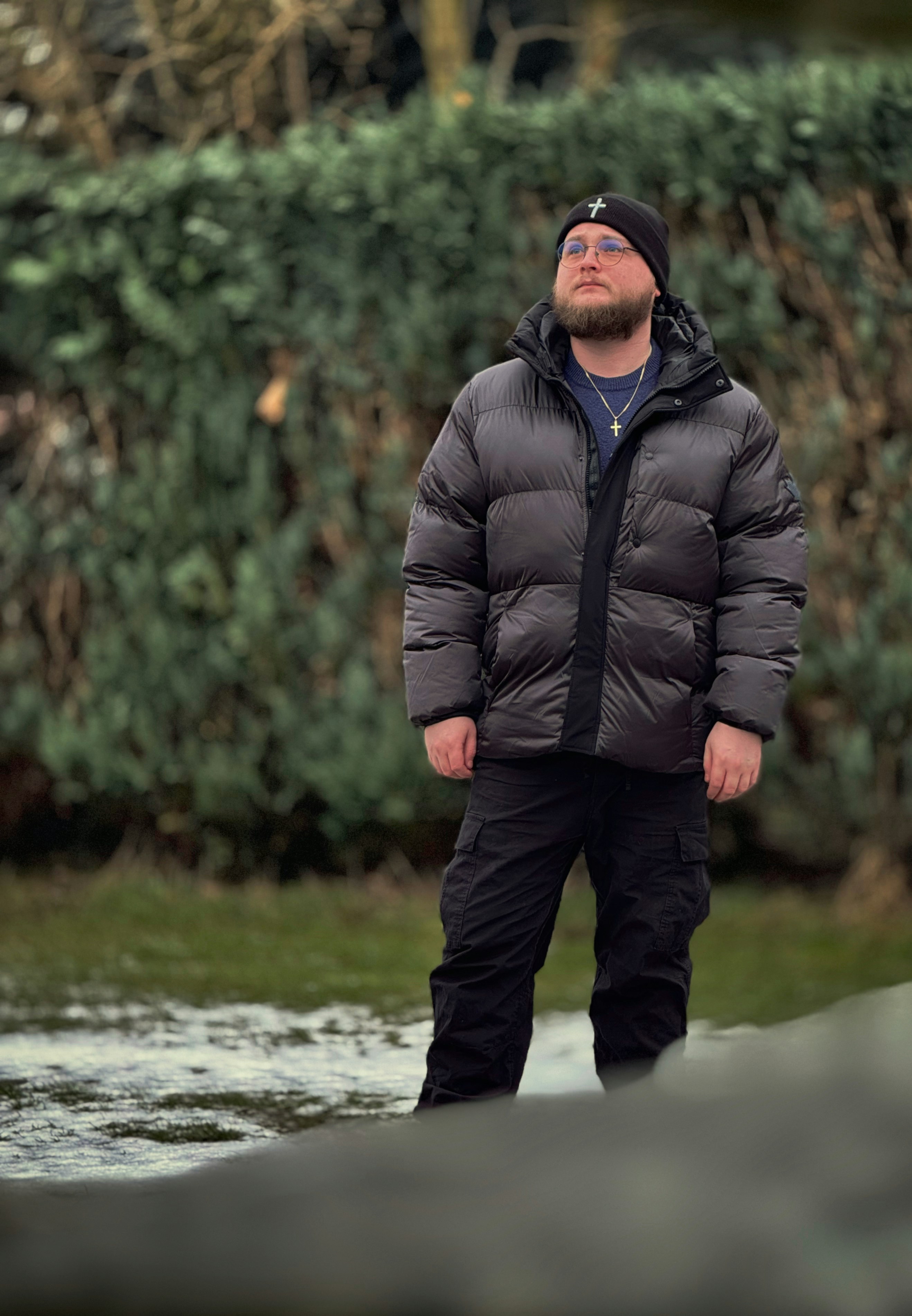 Um homem barbudo está ao ar livre vestindo um casaco de inverno
