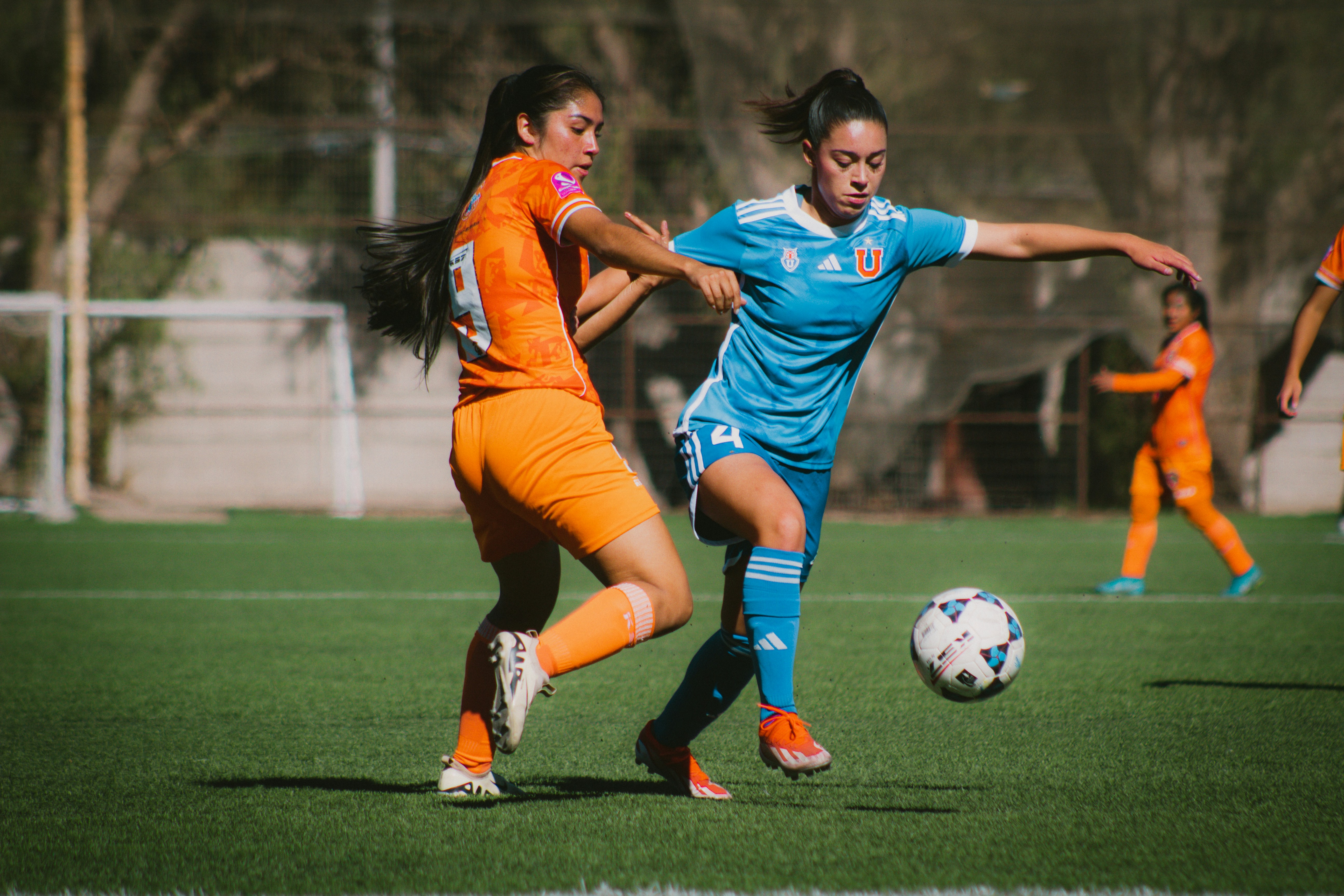 Zwei Fußballerinnen wetteifern um den Ball.