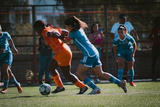 Soccer players compete for the ball on the field.