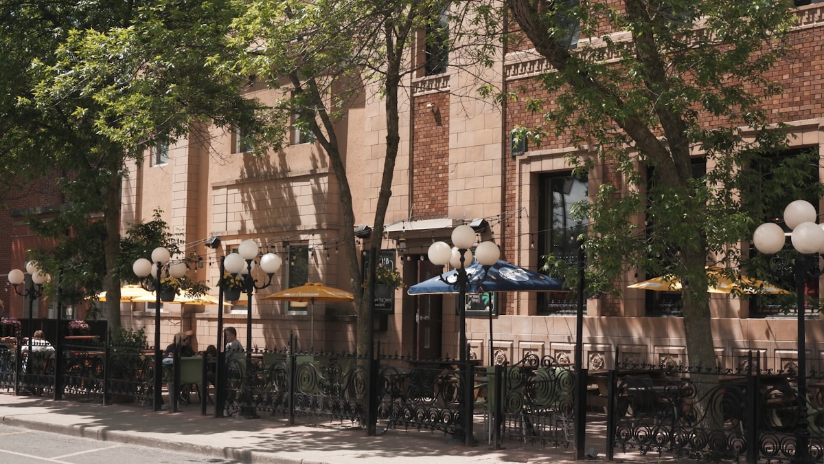 An outdoor cafe with sidewalk seating on a lively city street