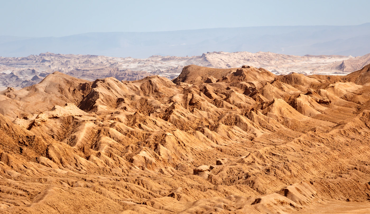 Dramatic eroded rock formations in the Atacama Desert Chile with the sculptural mineral landscape carved by wind against a clear blue high-altitude sky