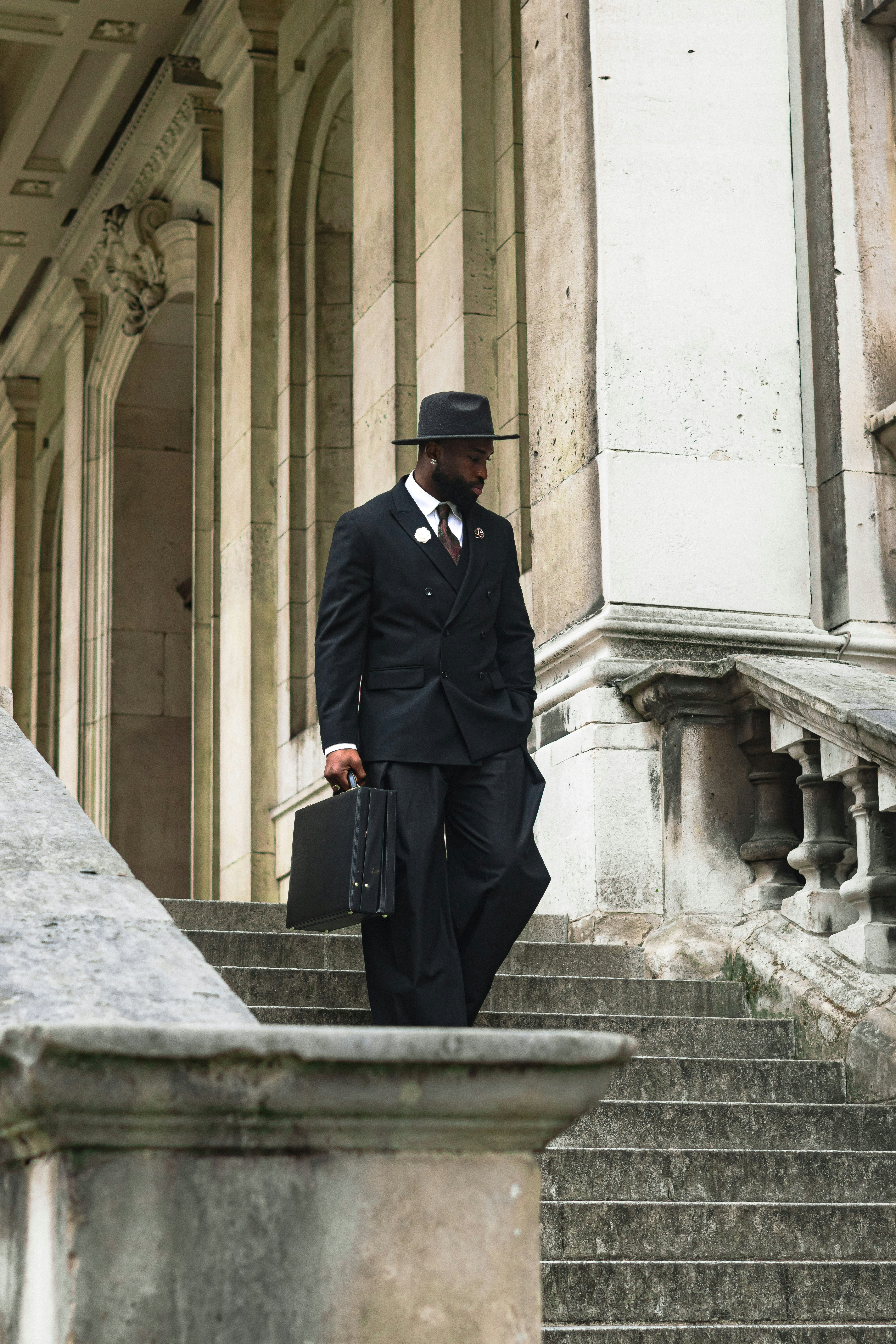 양복을 입은 남자가 계단을 걸어 내려간다. 사진 – Unsplash의 무료 남자 이미지
