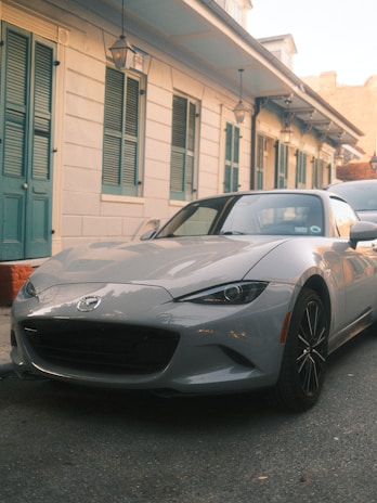 A gray sports car parked in front of a building.