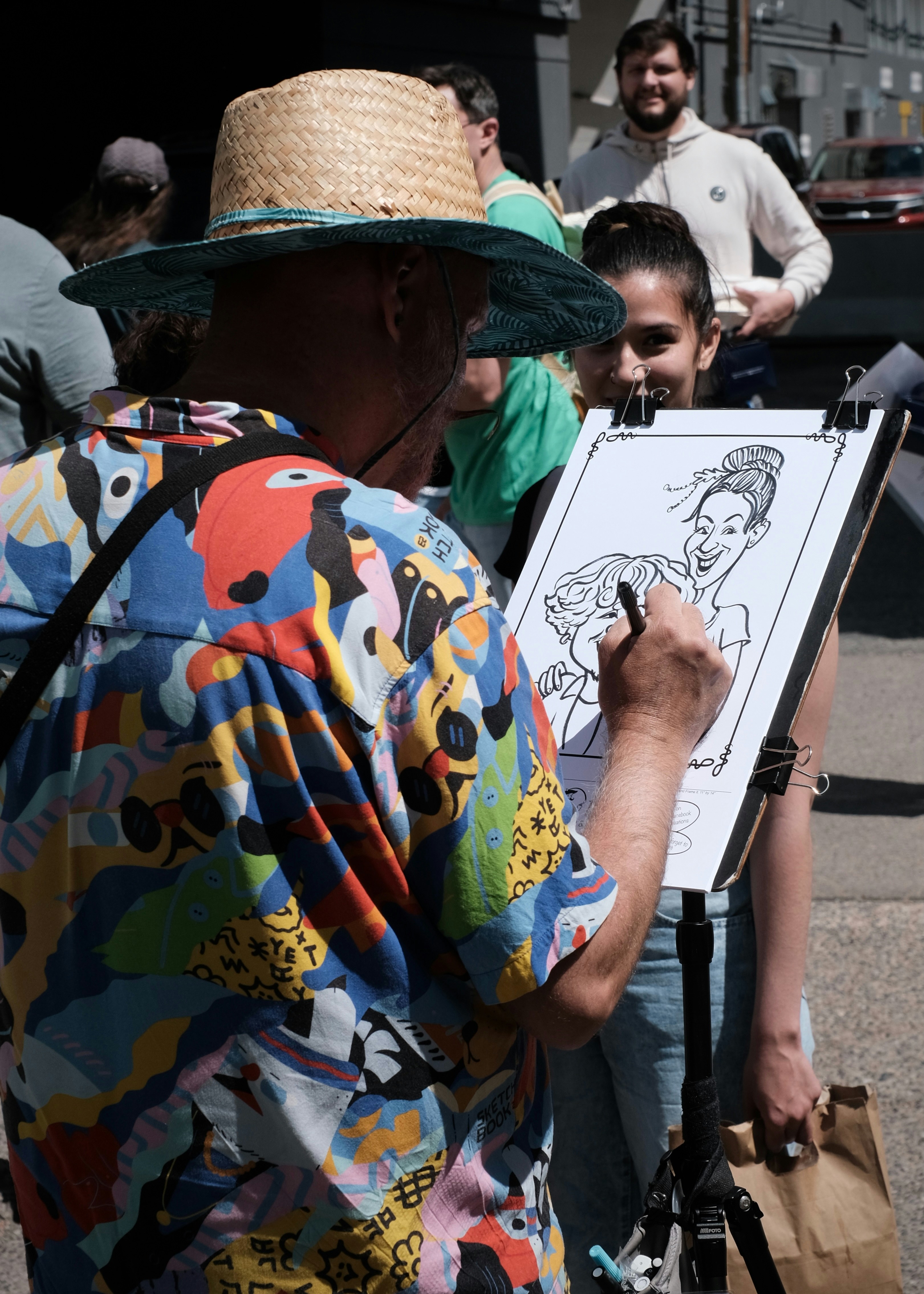 Artist sketches caricatures of two people.
