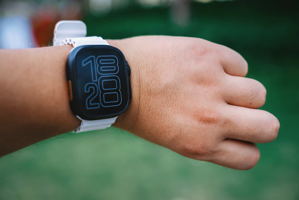 White square-face smartwatch on a wrist