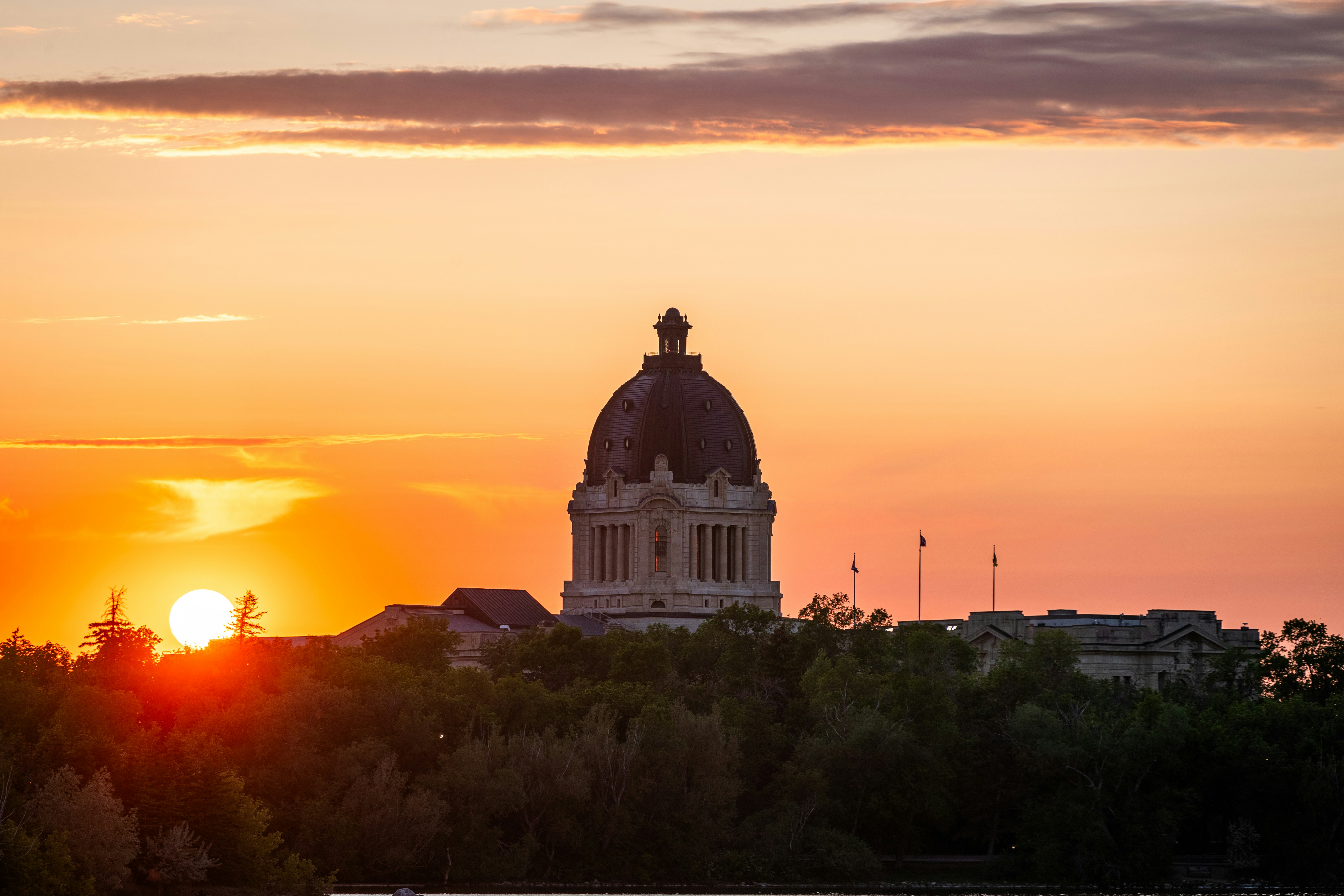 Sunset illuminates the dome of a building.