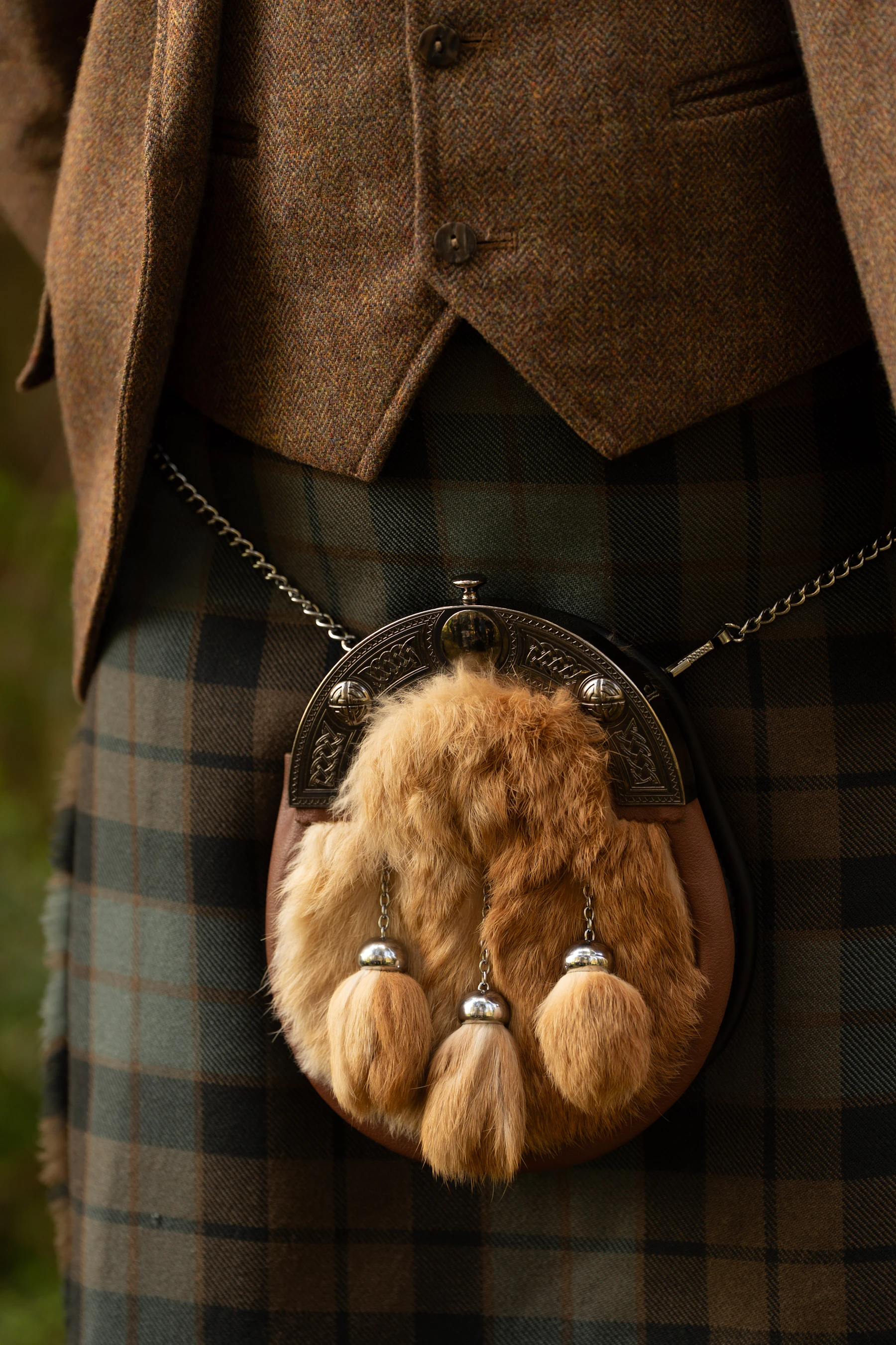 Close-up of a tartan kilt with a fur sporran hanging from a chain