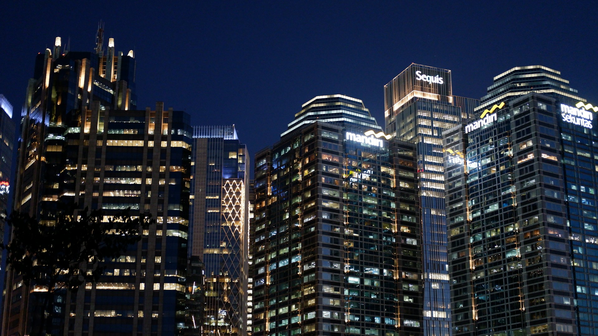 Skyscrapers shine brightly at night.