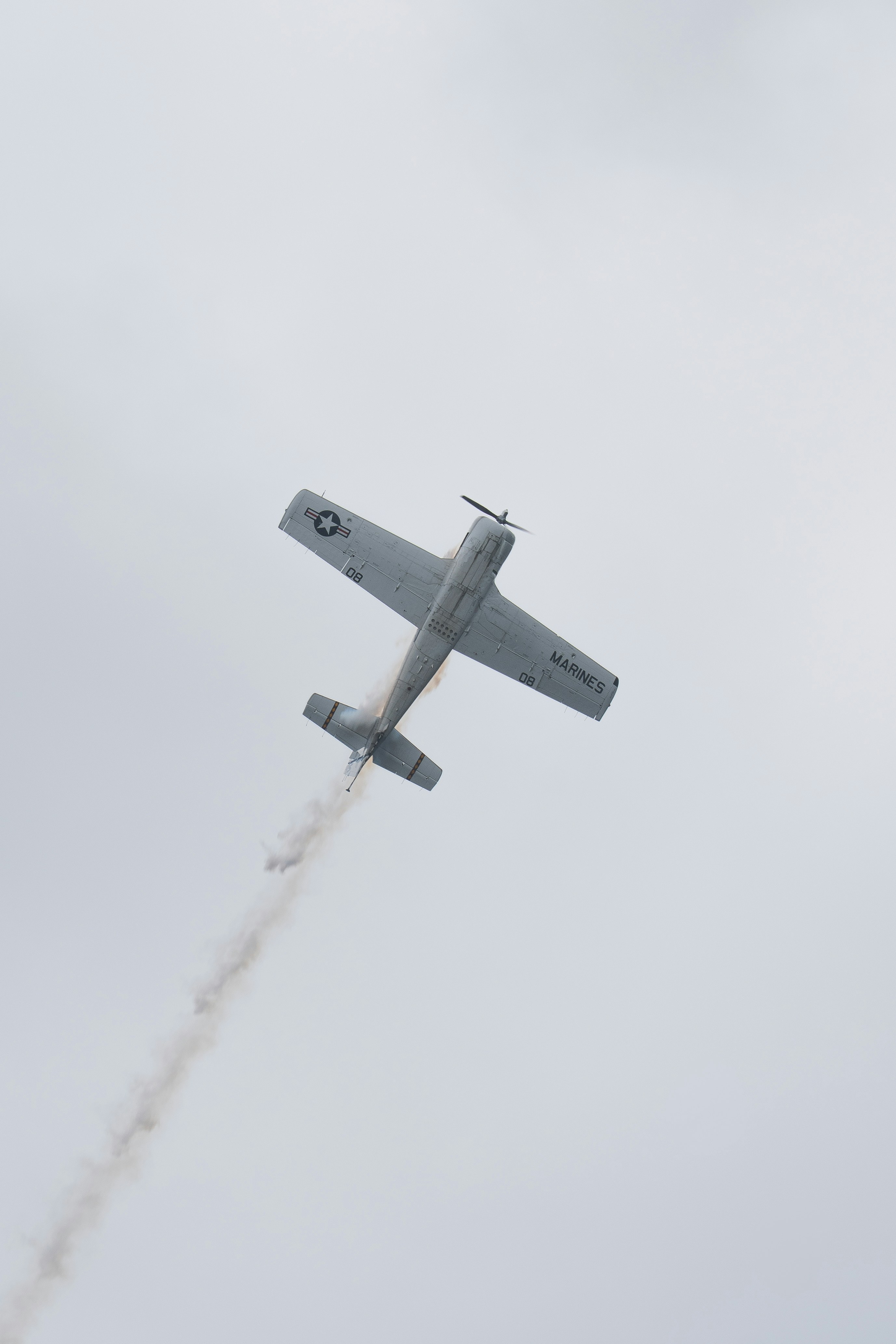 A small airplane flies across a cloudy sky.
