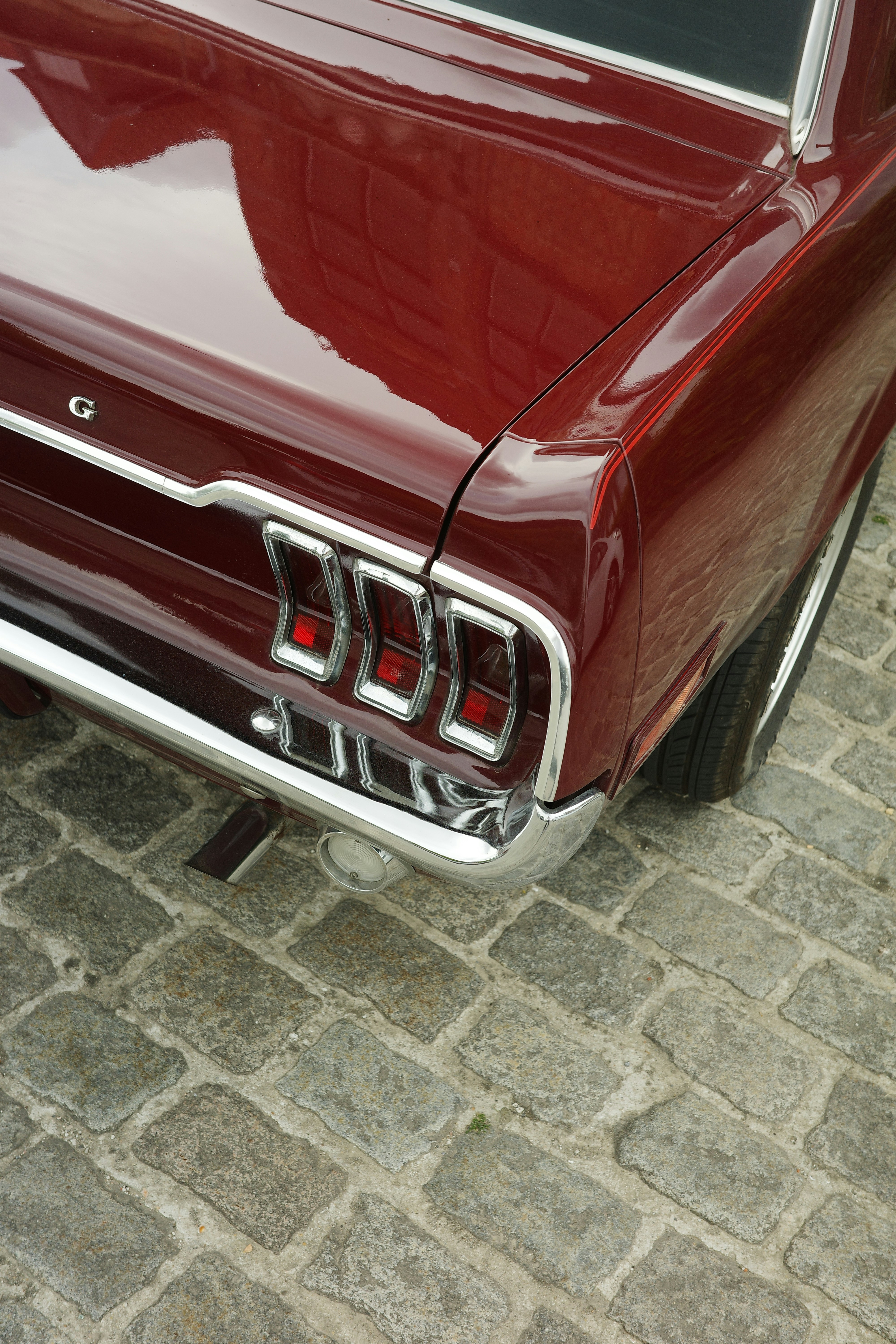 A red classic car's rear section is pictured.