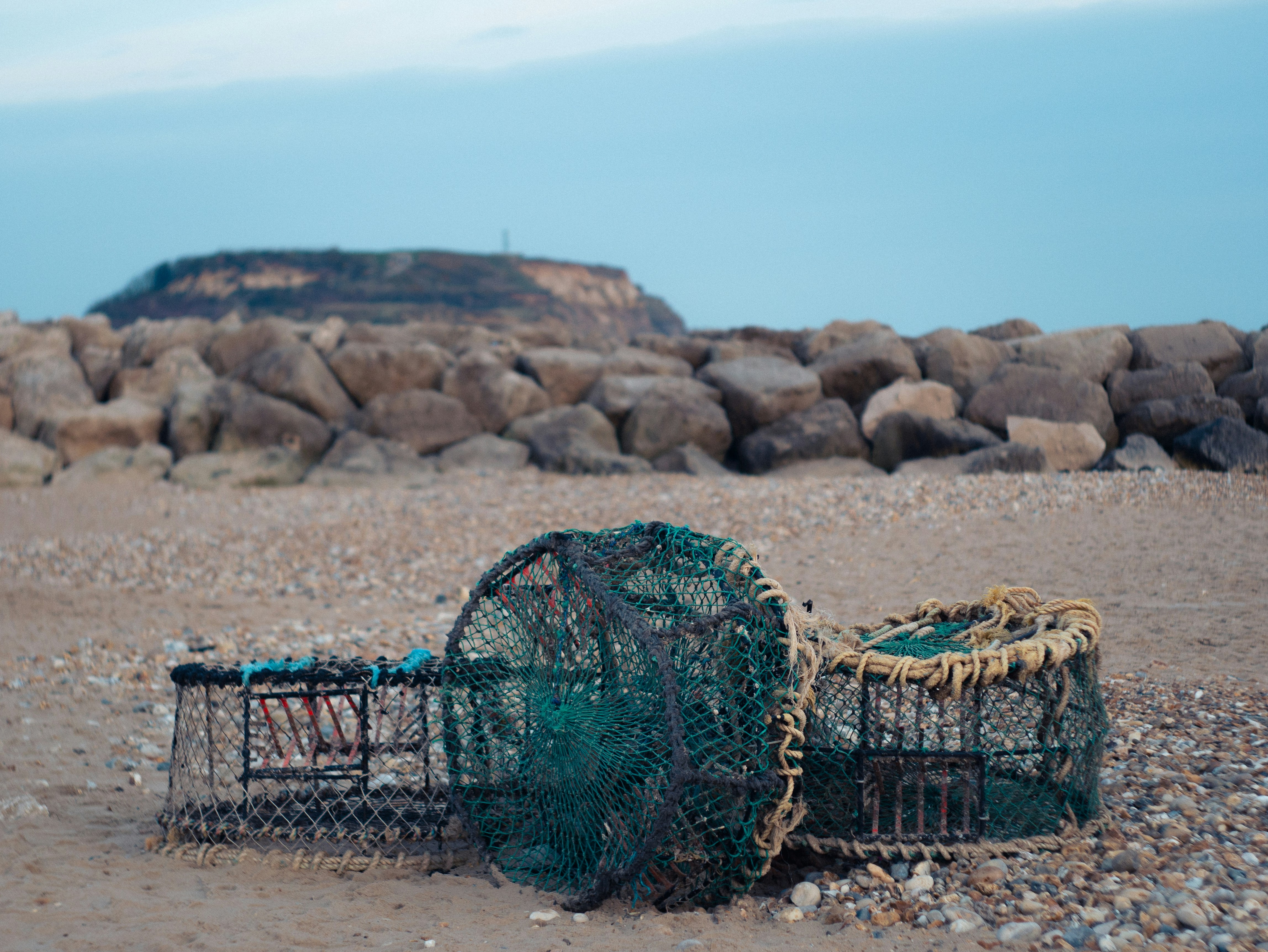 Lobster traps sit abandoned on a sandy beach