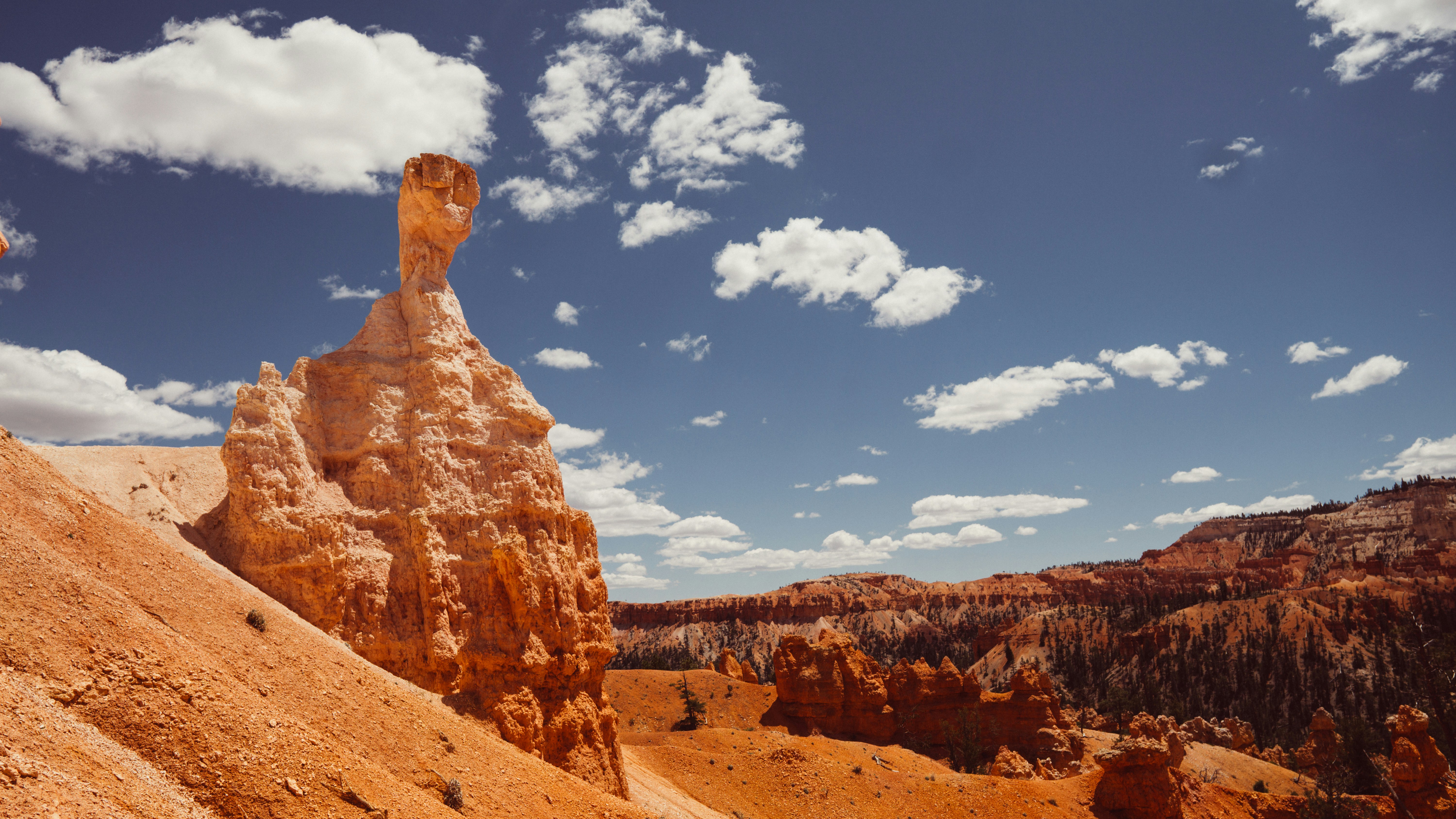 Dramatic rock formations under a blue, cloudy sky.