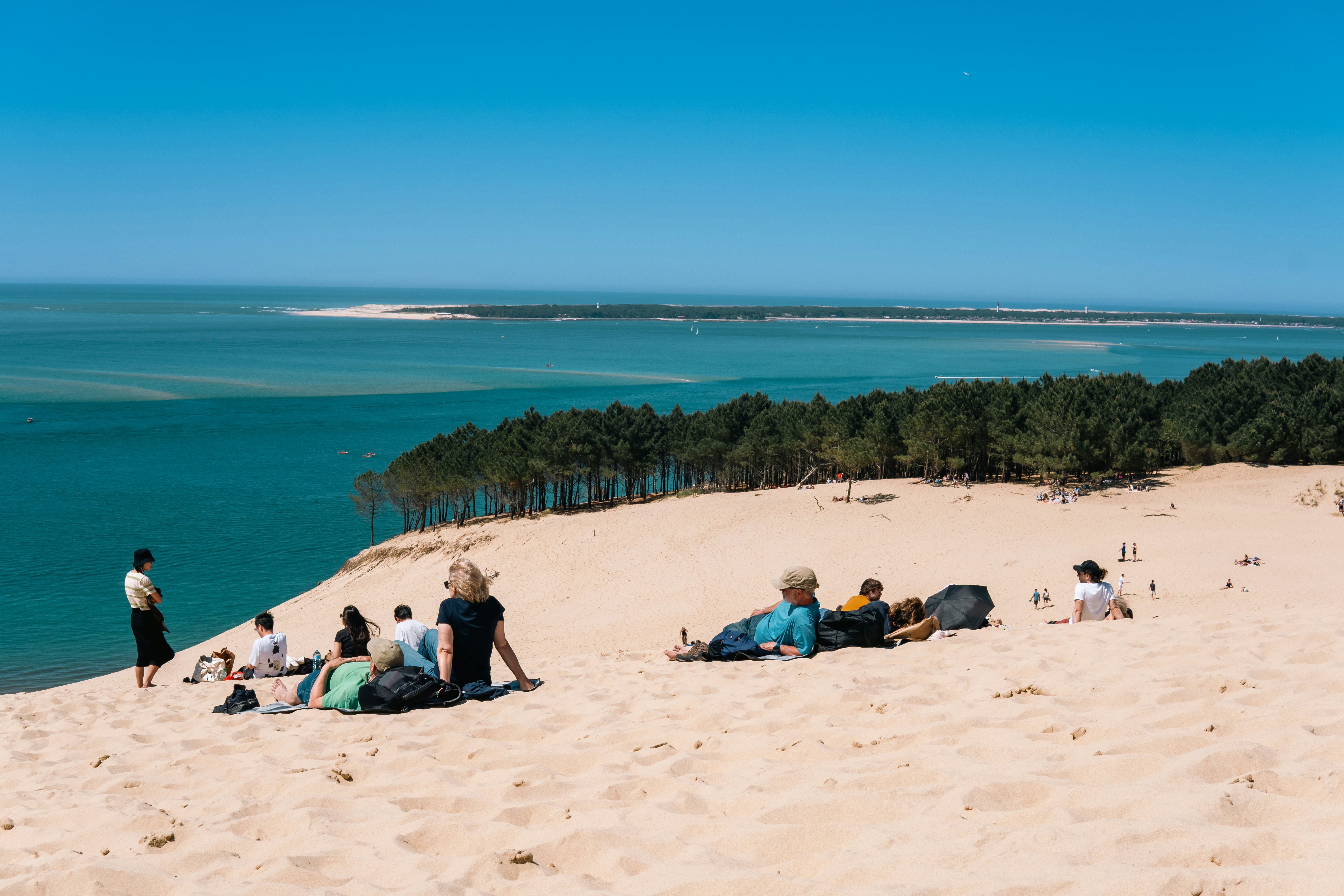 As pessoas aproveitam a praia em um dia ensolarado.
