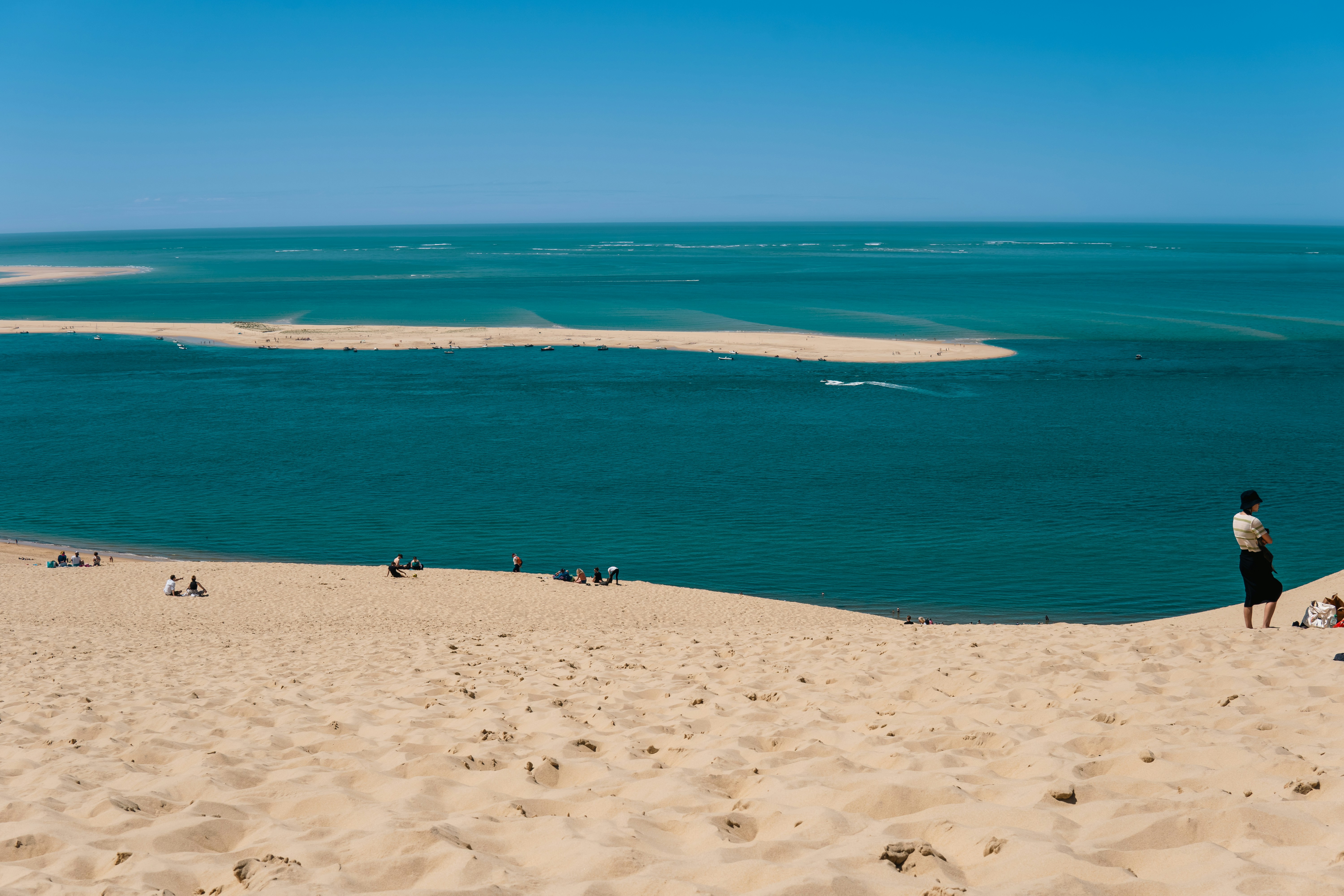 Sandy dunes overlook a beautiful turquoise ocean view.