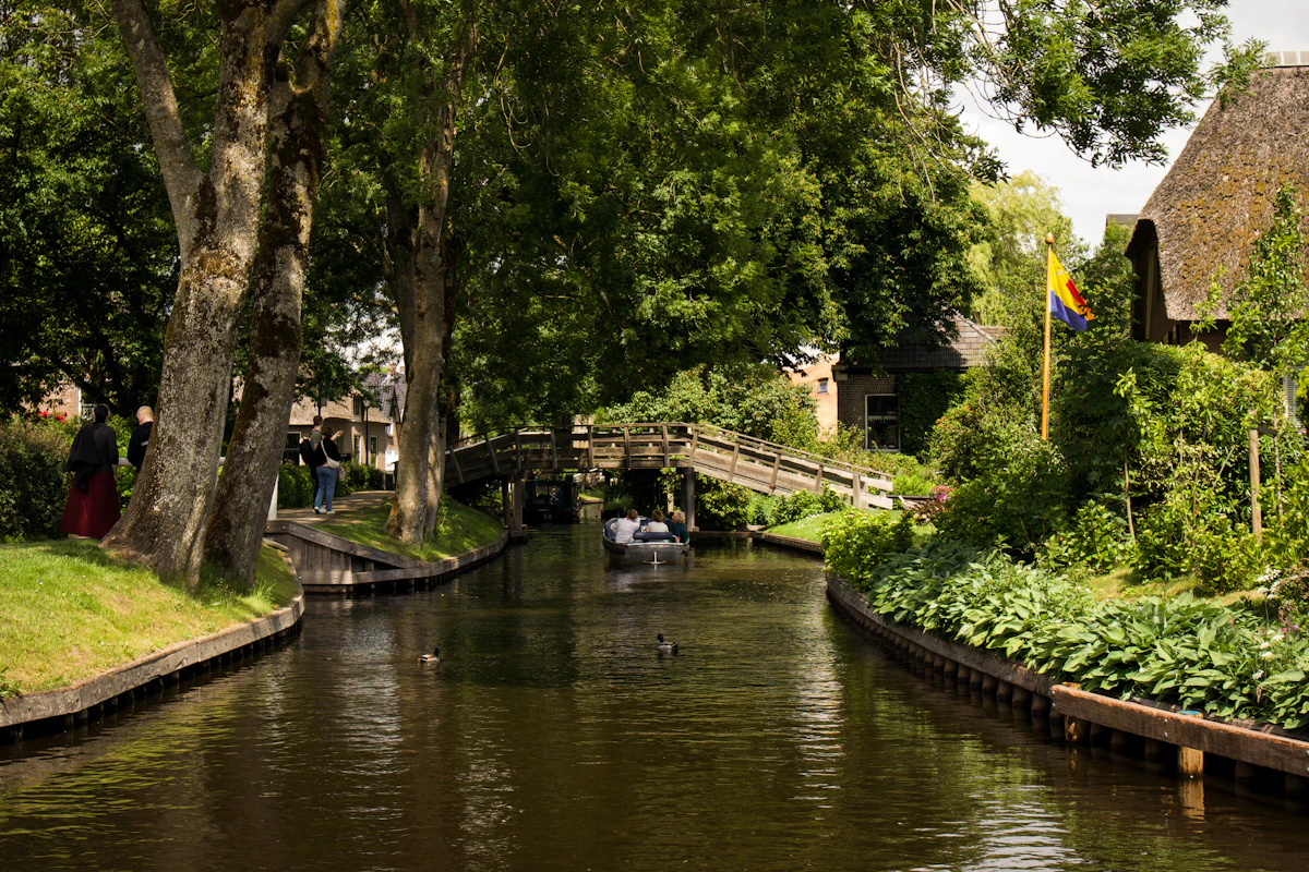 Groene Nederlandse waterweg met brug en traditionele huizen