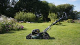 A lawnmower sits on a grassy lawn.