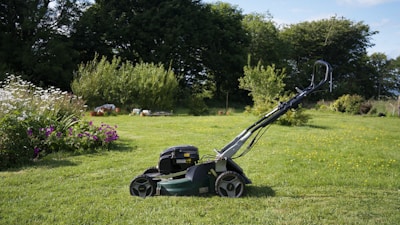 A lawnmower sits on a grassy lawn.