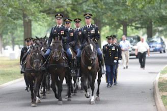 Soldiers on horseback lead a procession forward.