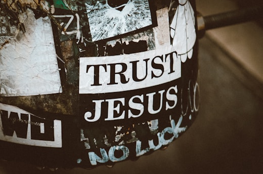A sticker says "trust jesus" on a worn surface.