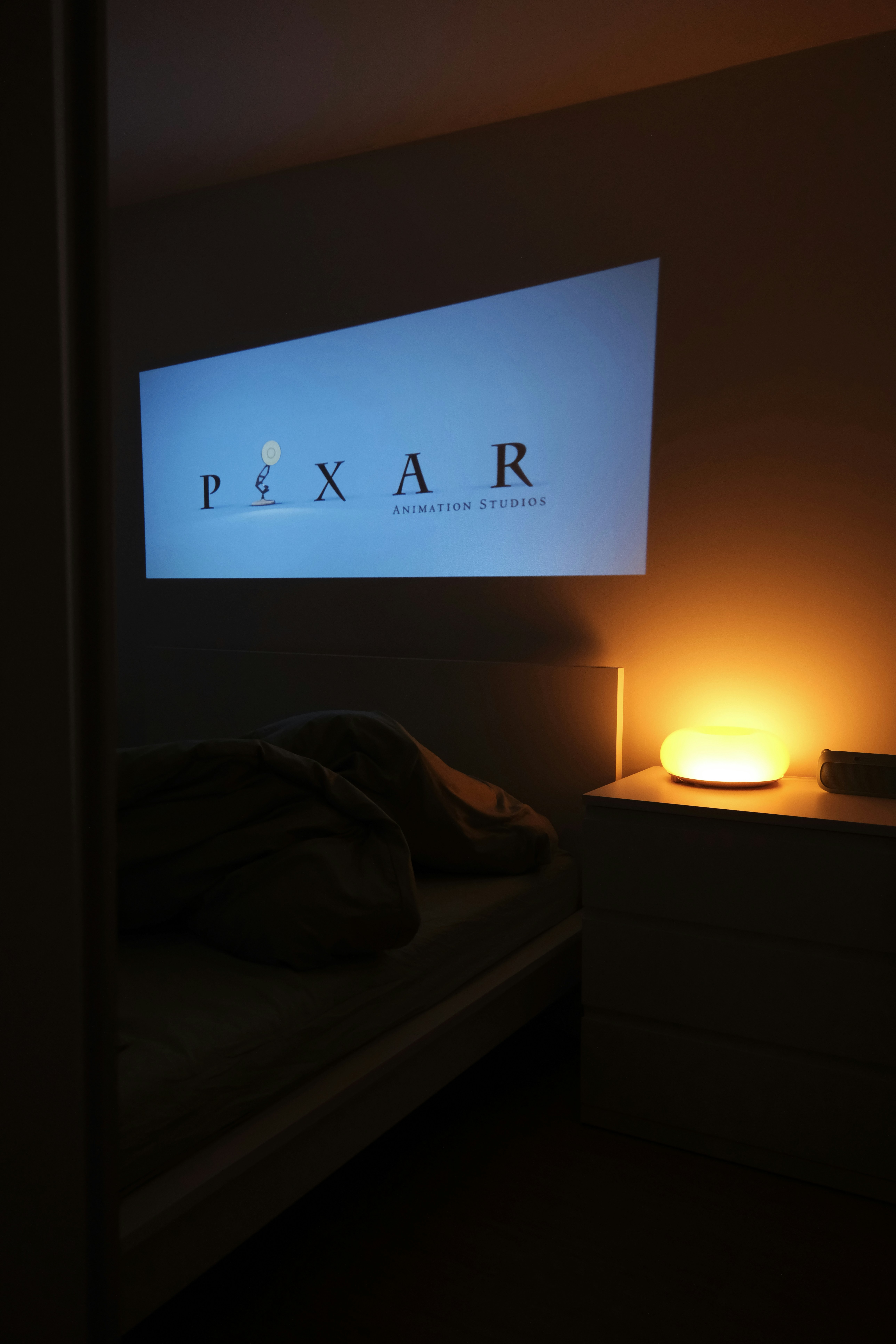 A cozy bedroom with a pixar movie projection