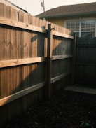 Wooden fence and yard in the evening sunlight.