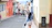 Woman walks down a colorful street in a city.