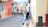 Woman walks down a colorful street in a city.