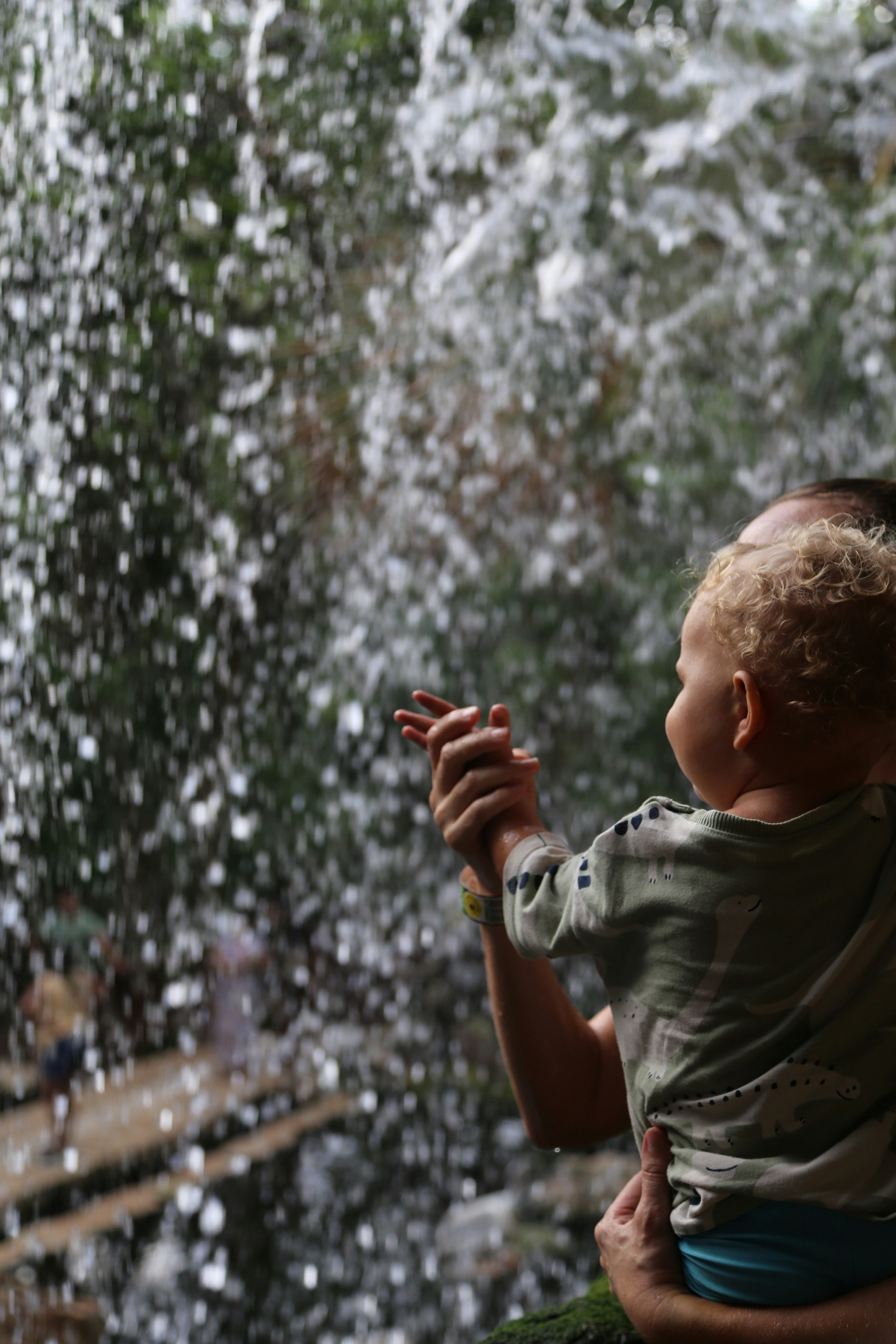 Un enfant et un adulte regardent une cascade.