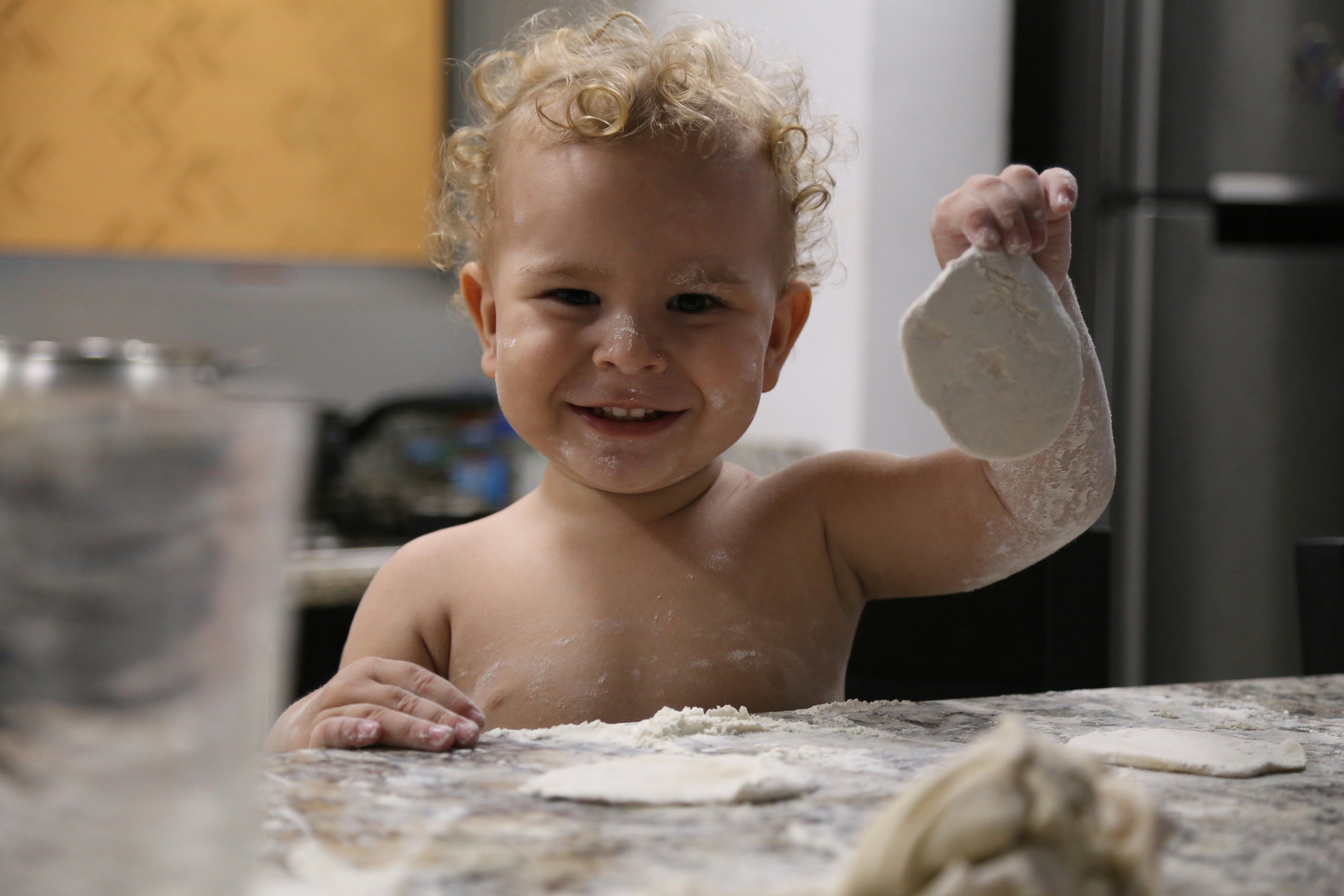 طفل يقيس الدقيق بكوب قياس