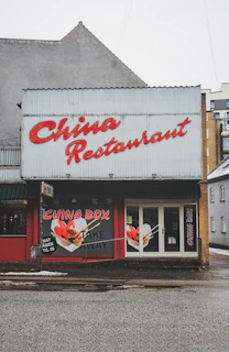 A chinese restaurant displays its name and take away option.