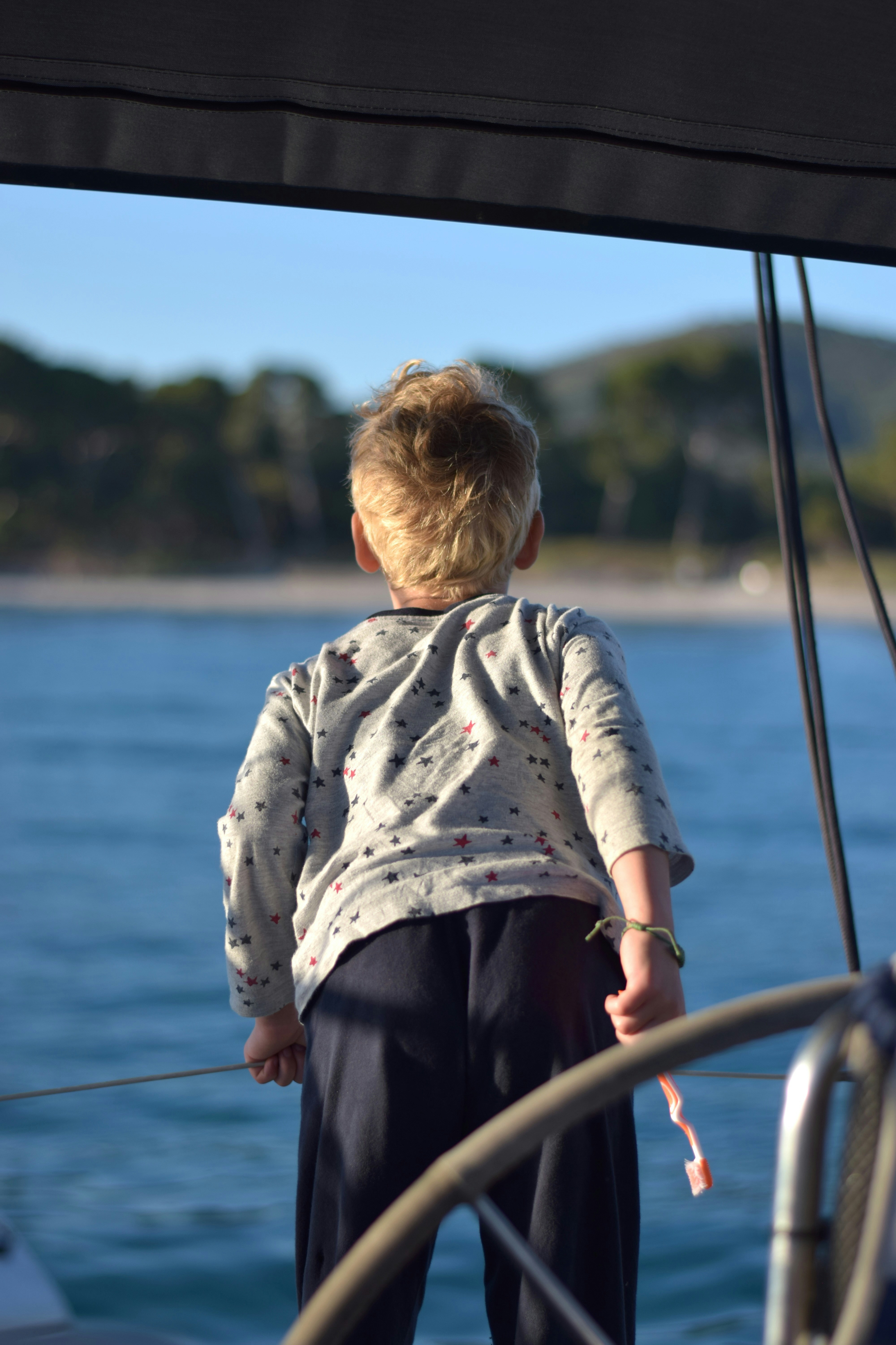 A child observes the sea from a sailboat.