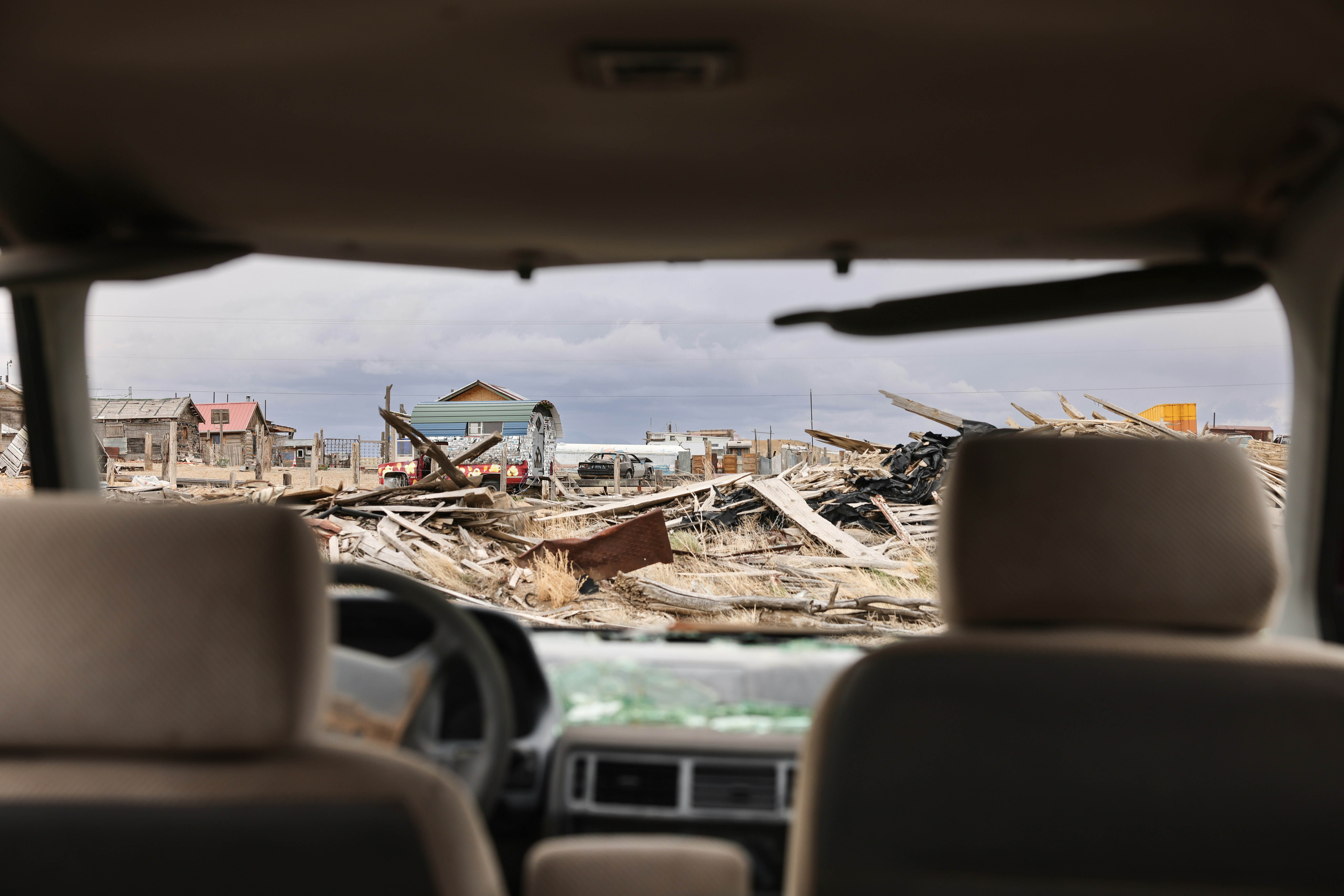 Blick aus dem Autofenster auf zerstörte Gebäude.