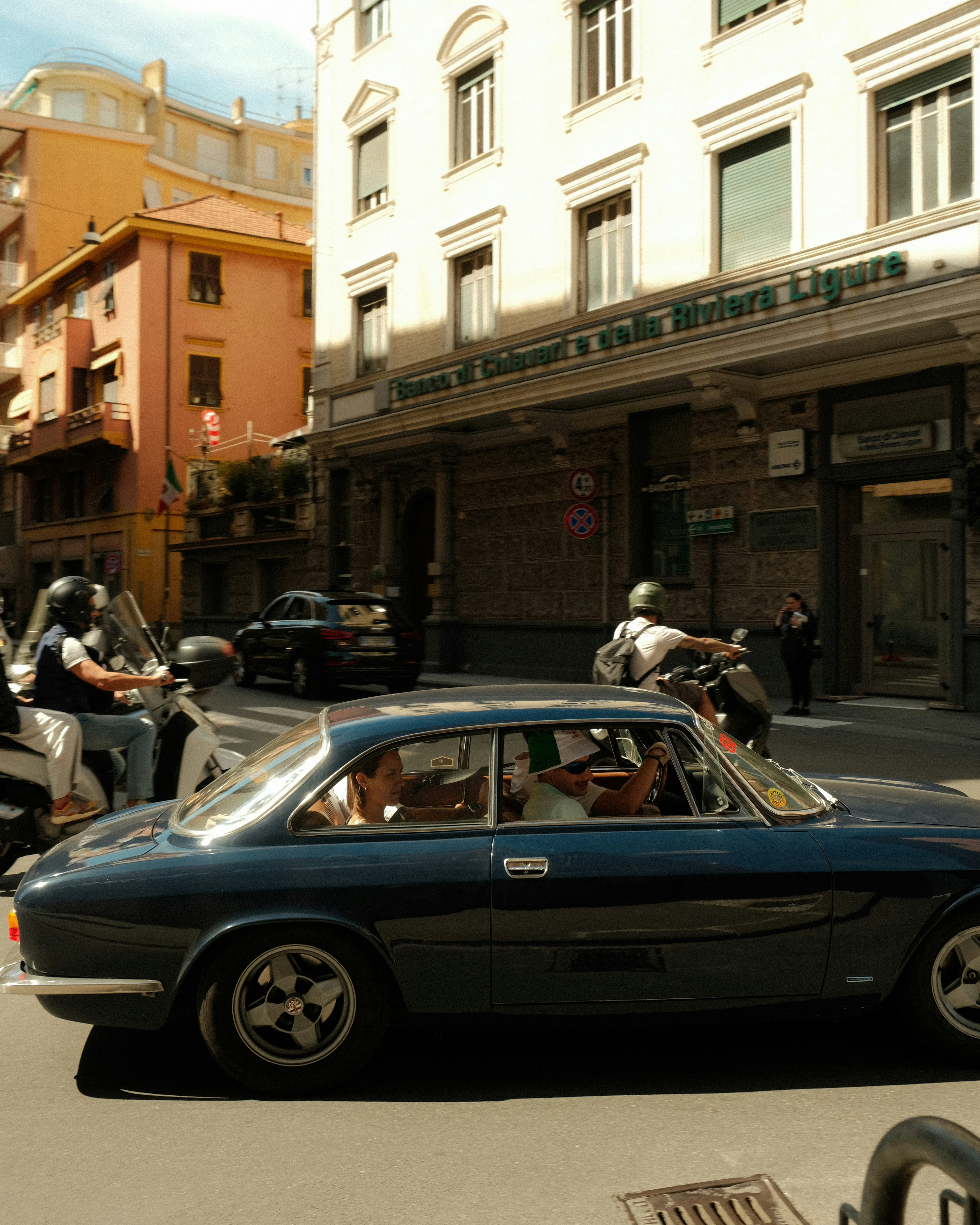 A classic car drives down a european street