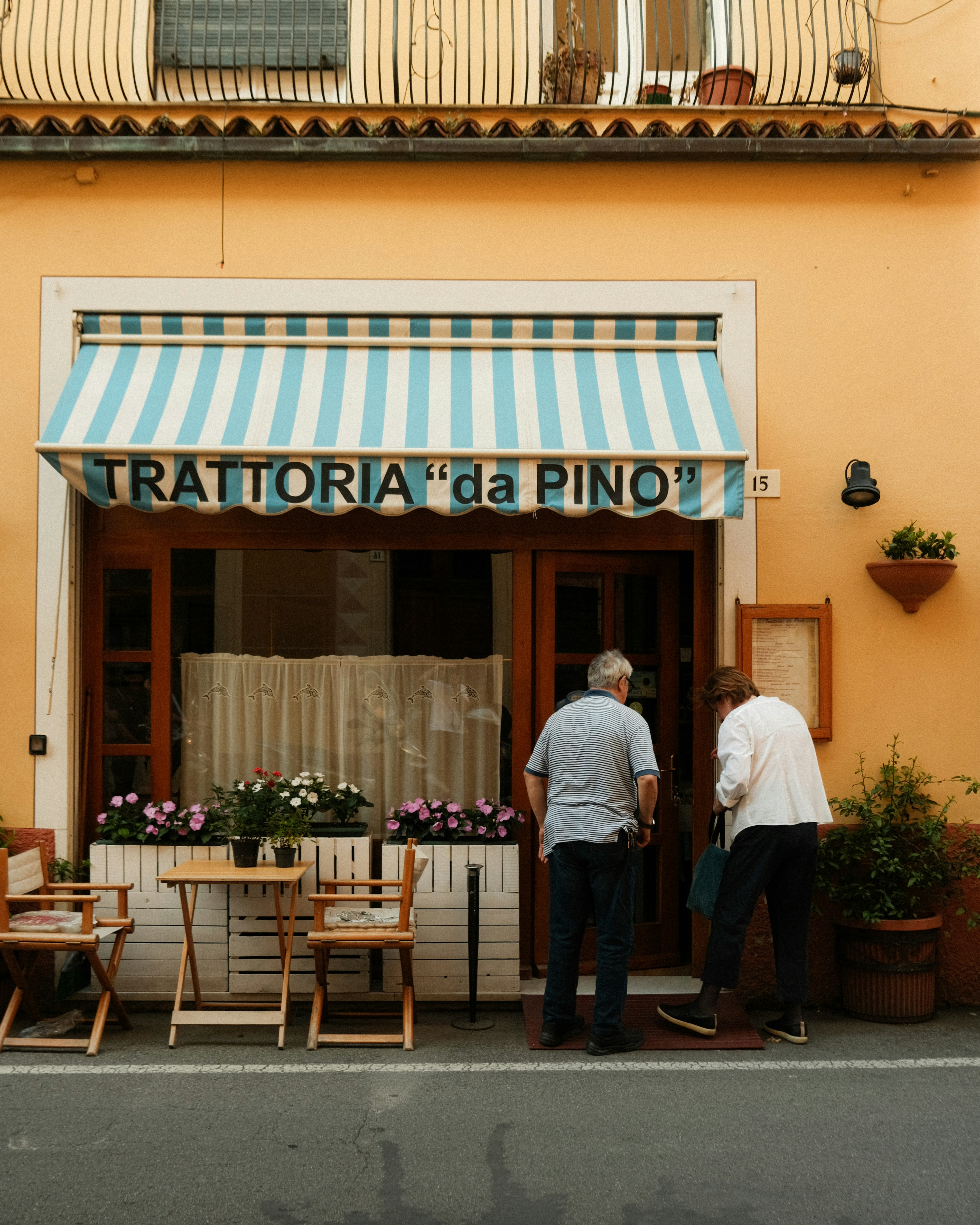 People enter a restaurant called "trattoria da pino".