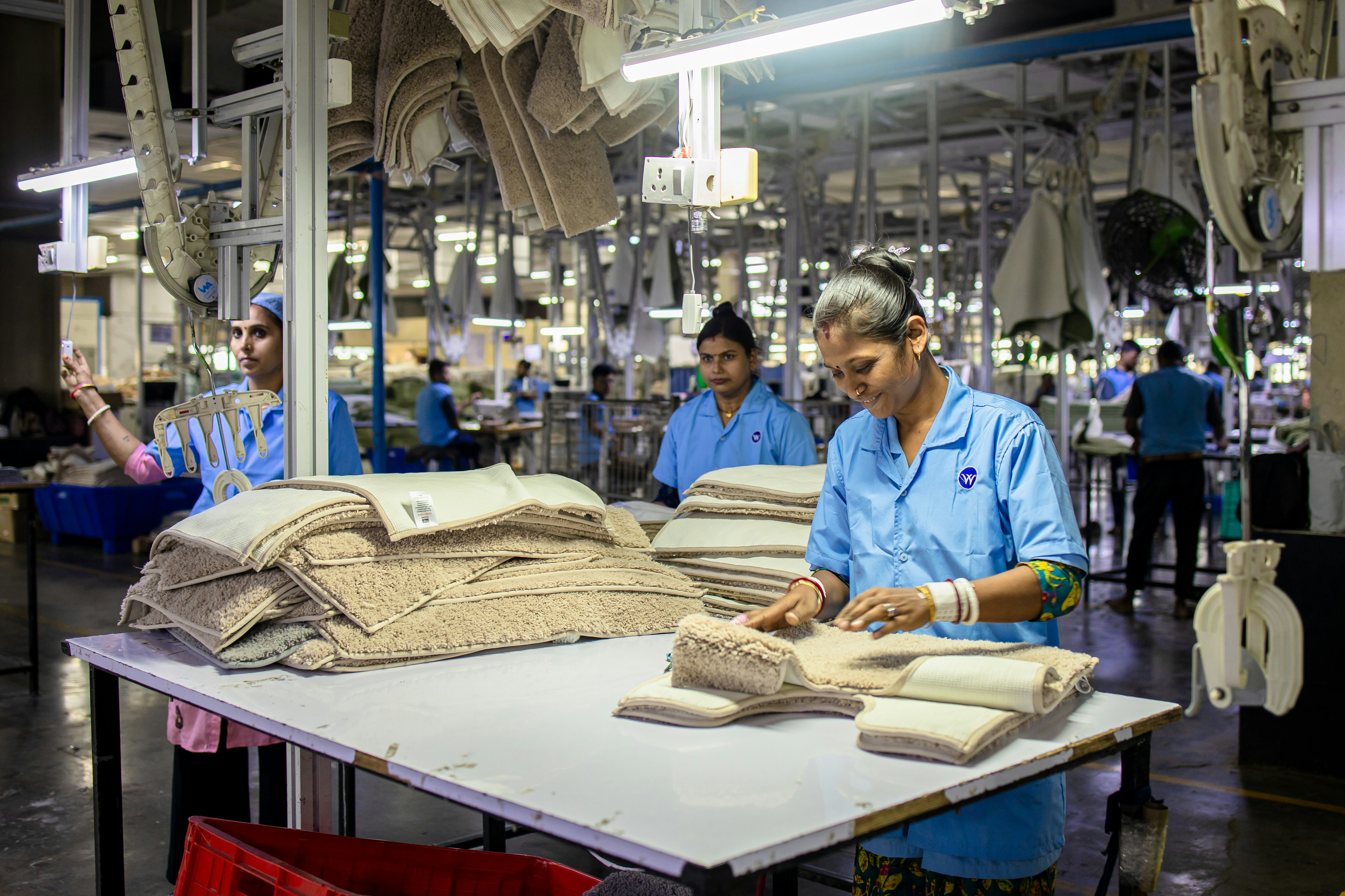 Des ouvriers plient des articles dans une usine.