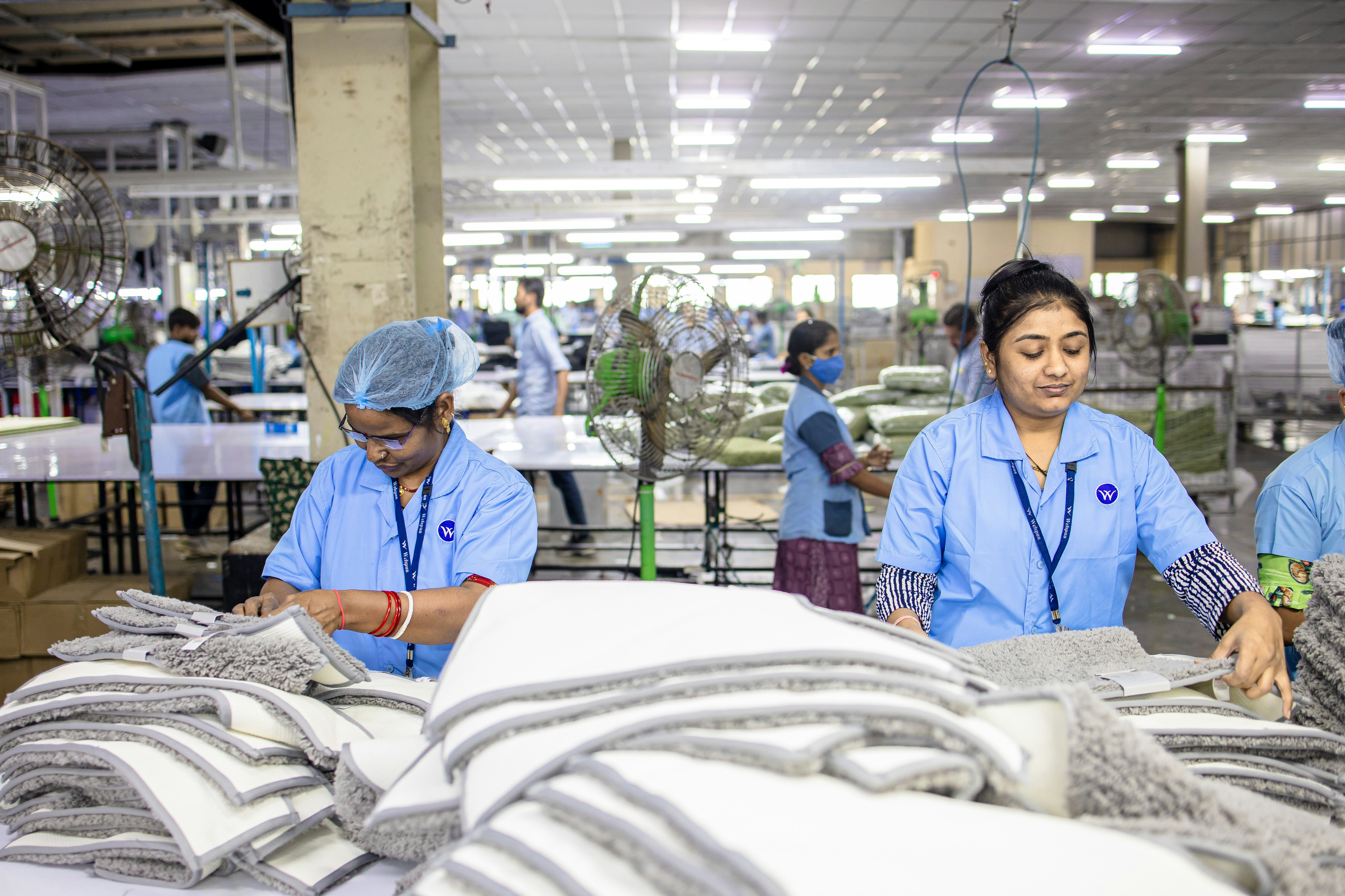 Workers assemble textiles in a bustling factory.