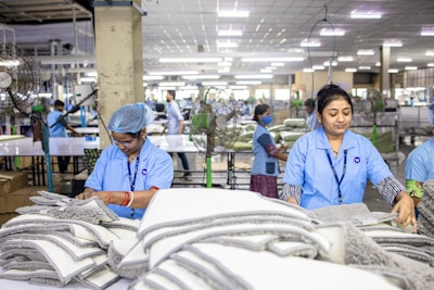Workers assemble textiles in a bustling factory.