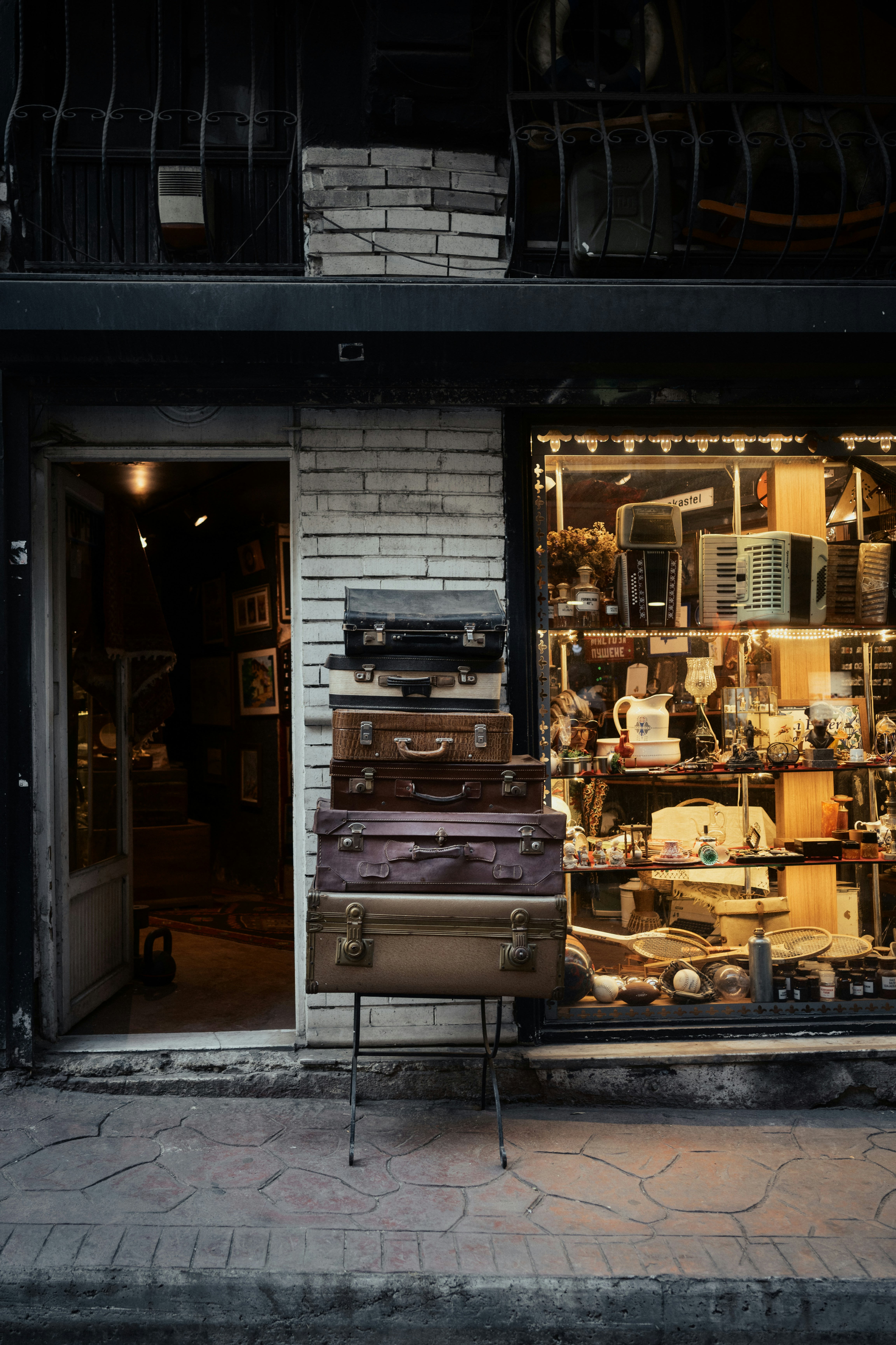 Vintage suitcases are stacked outside an antique store.