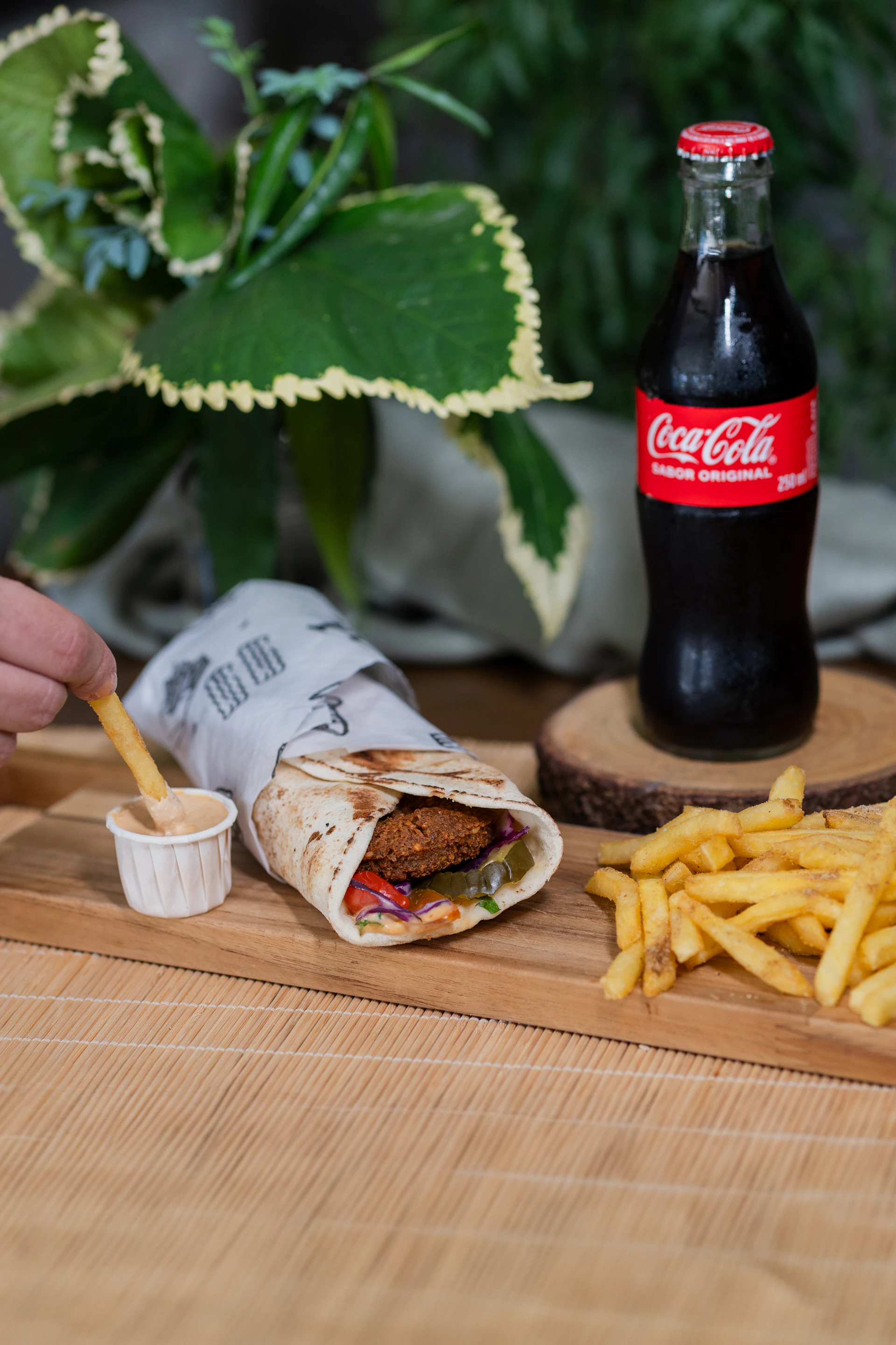 A falafel wrap with fries and coca-cola.