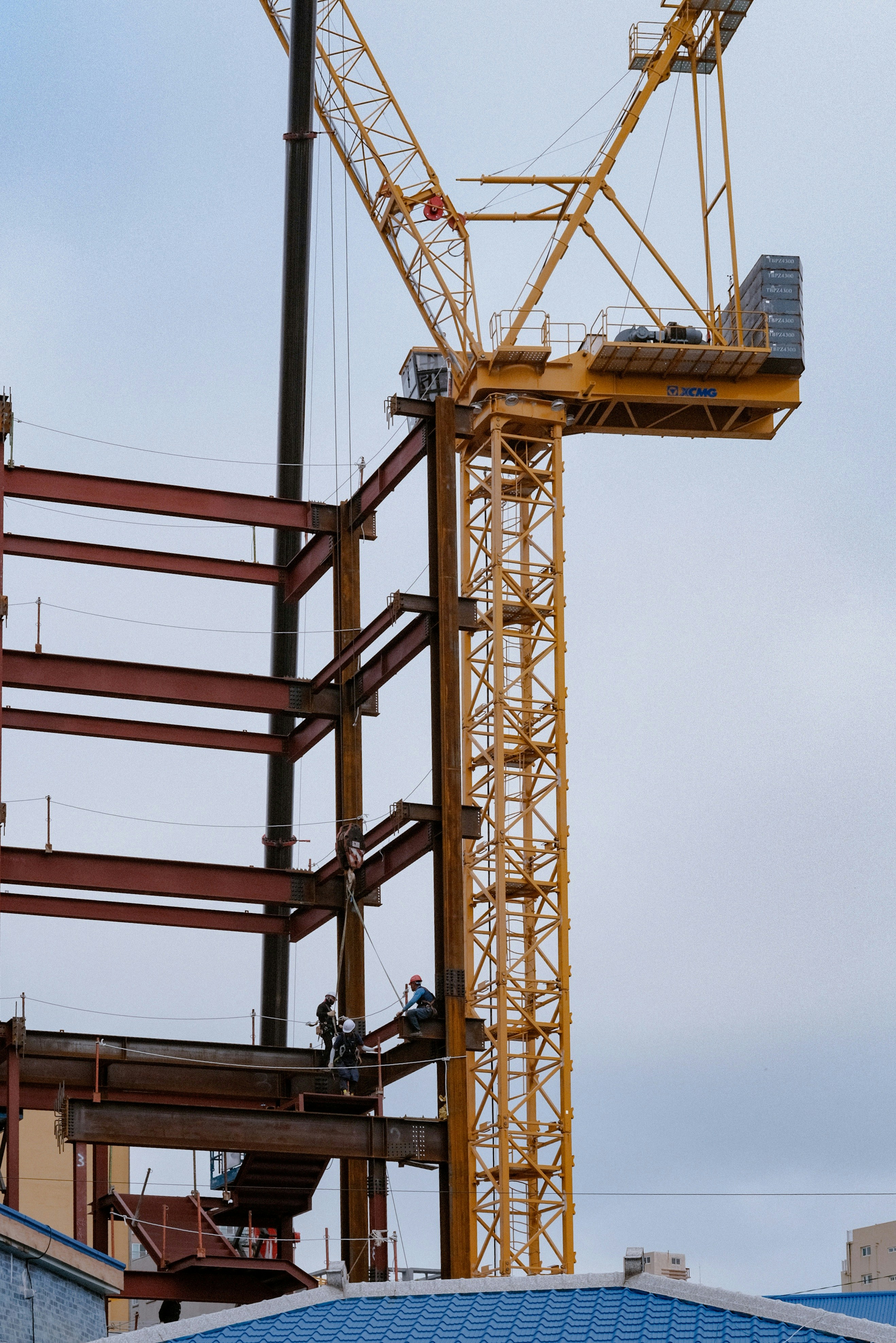 Construction workers are on a building site with a crane.