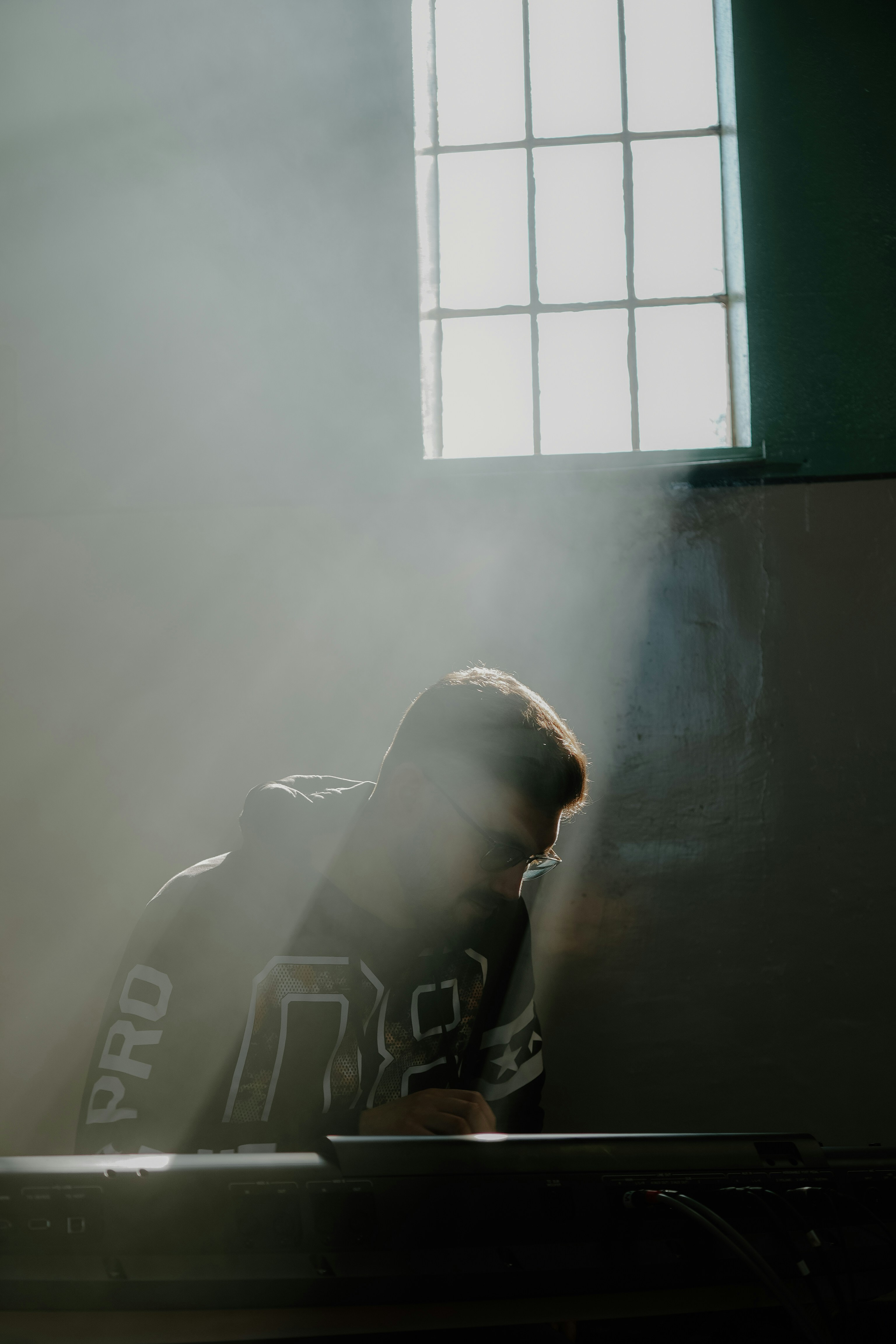 A man plays keyboard in a smoky room.