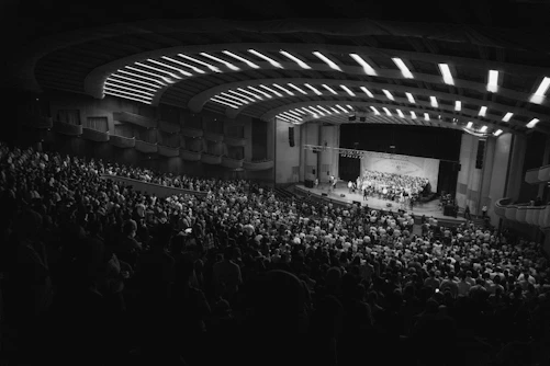 An orchestra performs for a large, attentive audience.
