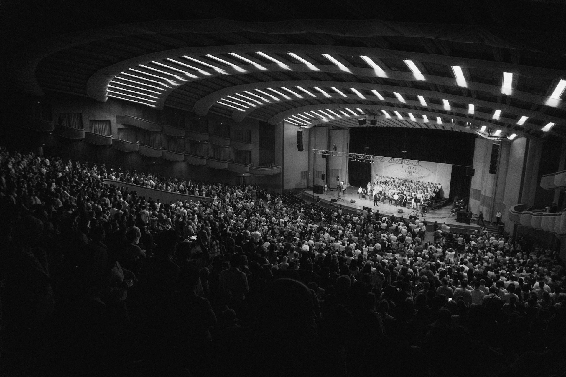 An orchestra performs for a large, attentive audience.
