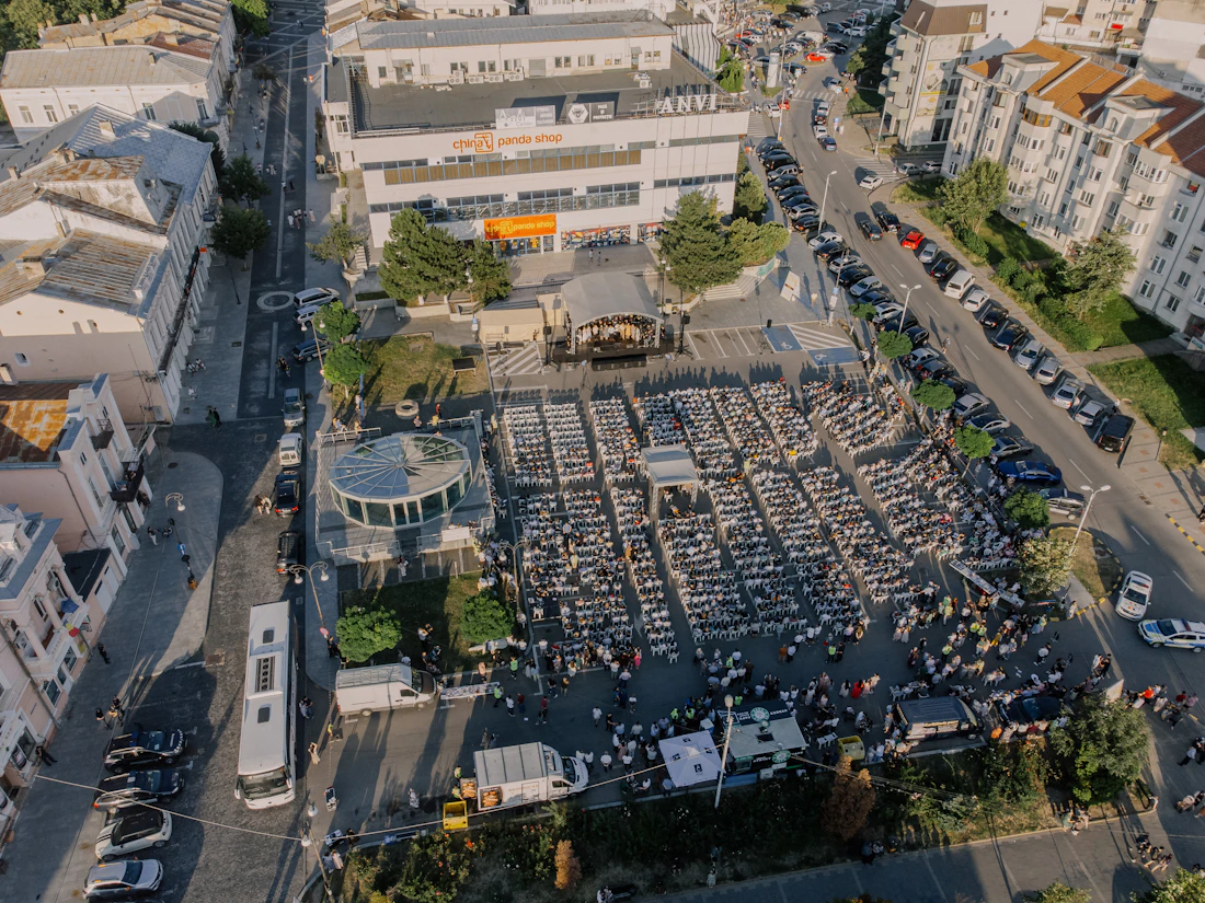 Drone view of a large outdoor event with seating, crowd areas and site layout