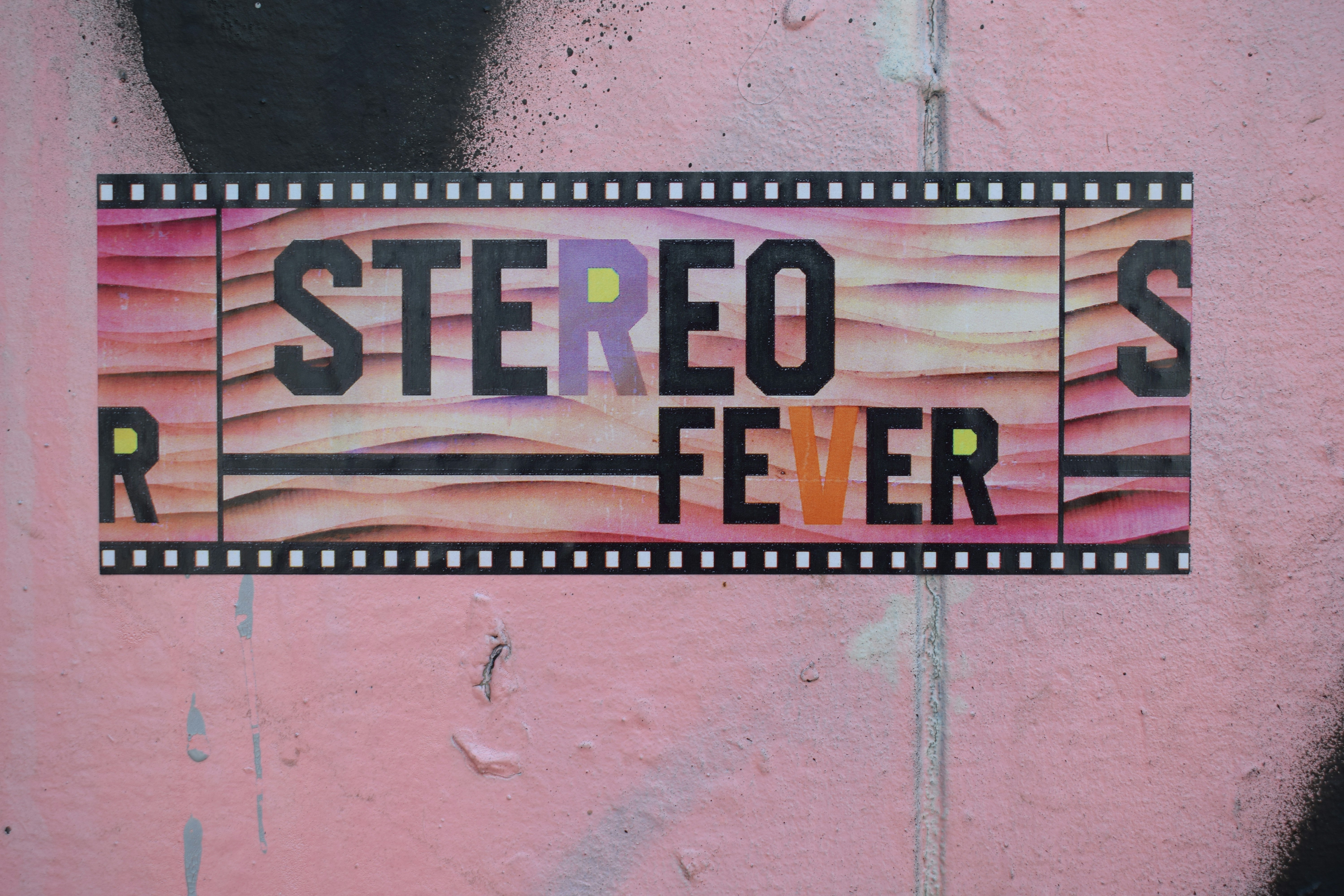 Stereo fever is written on a pink wall.