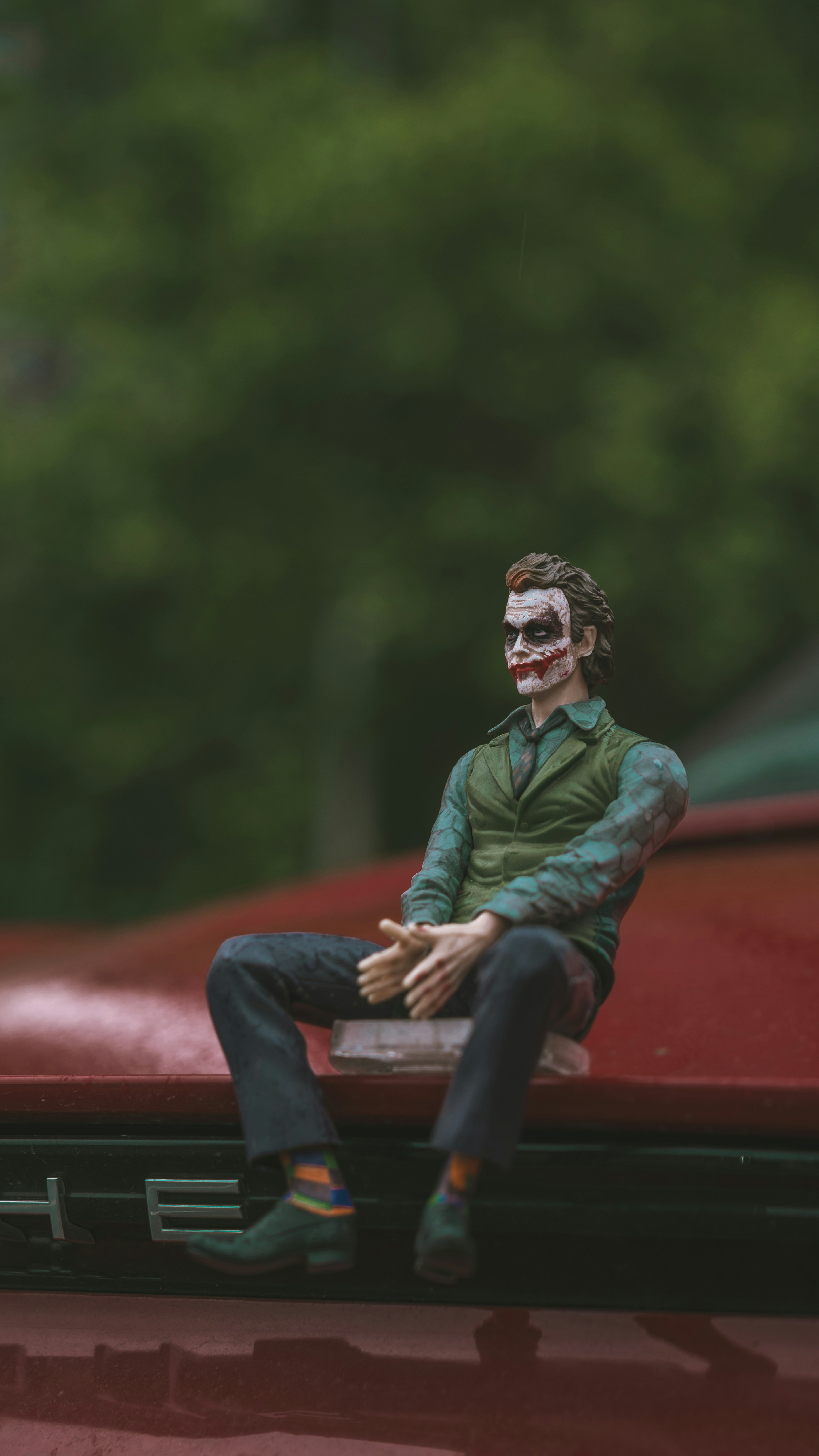 Joker figurine sits on a car's hood.