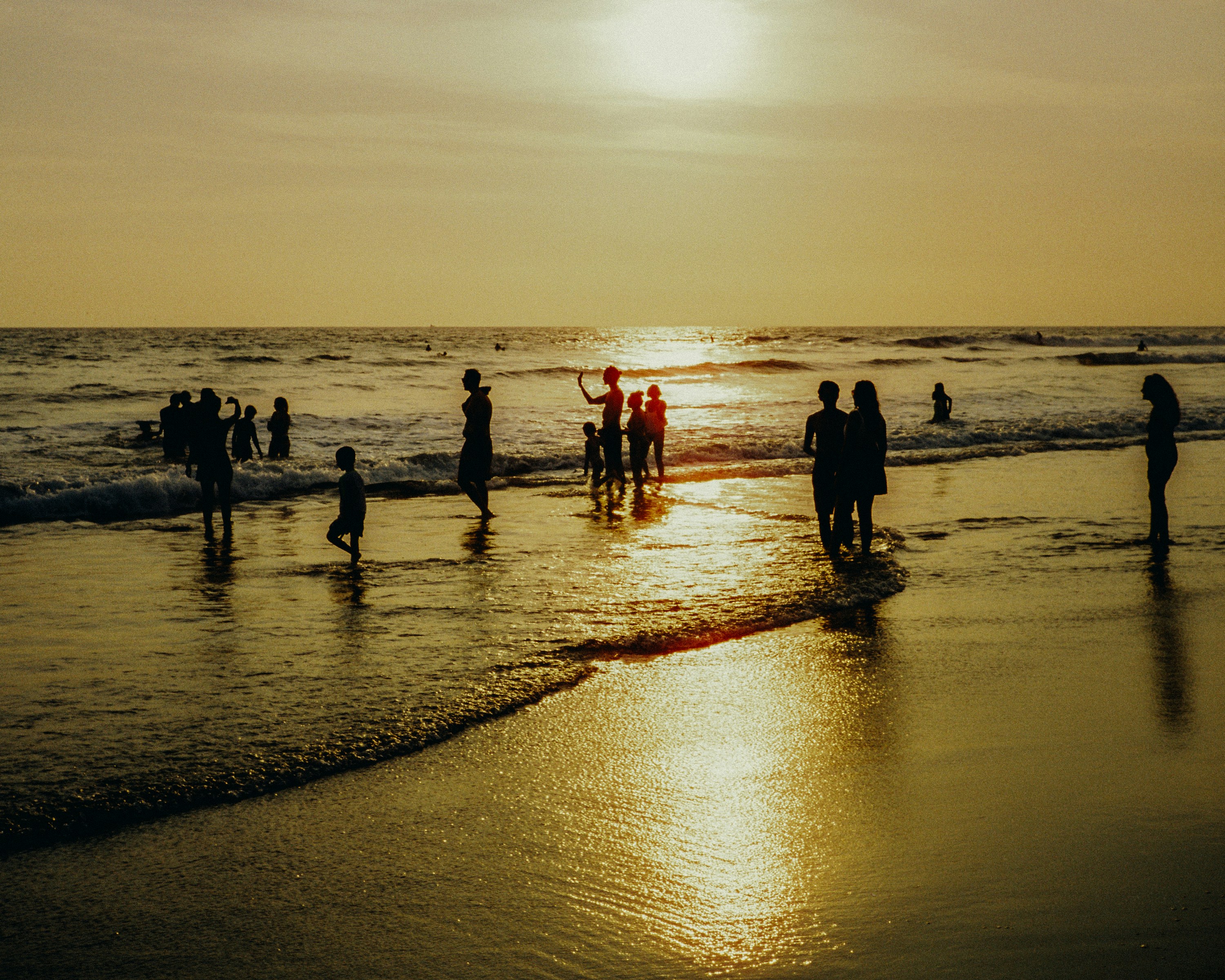 Die Leute genießen den Strand bei Sonnenuntergang.