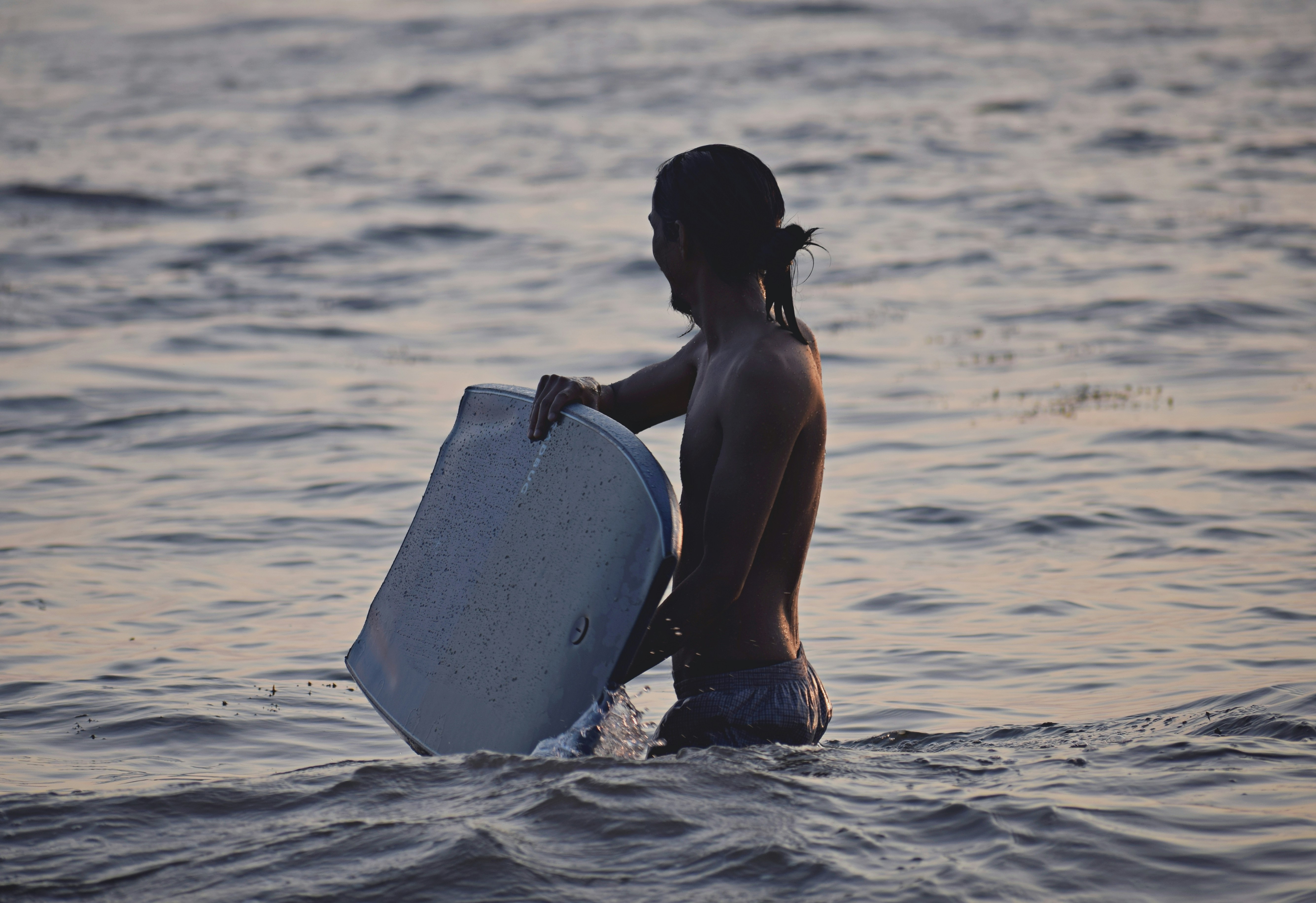 A person carries a container in the water.