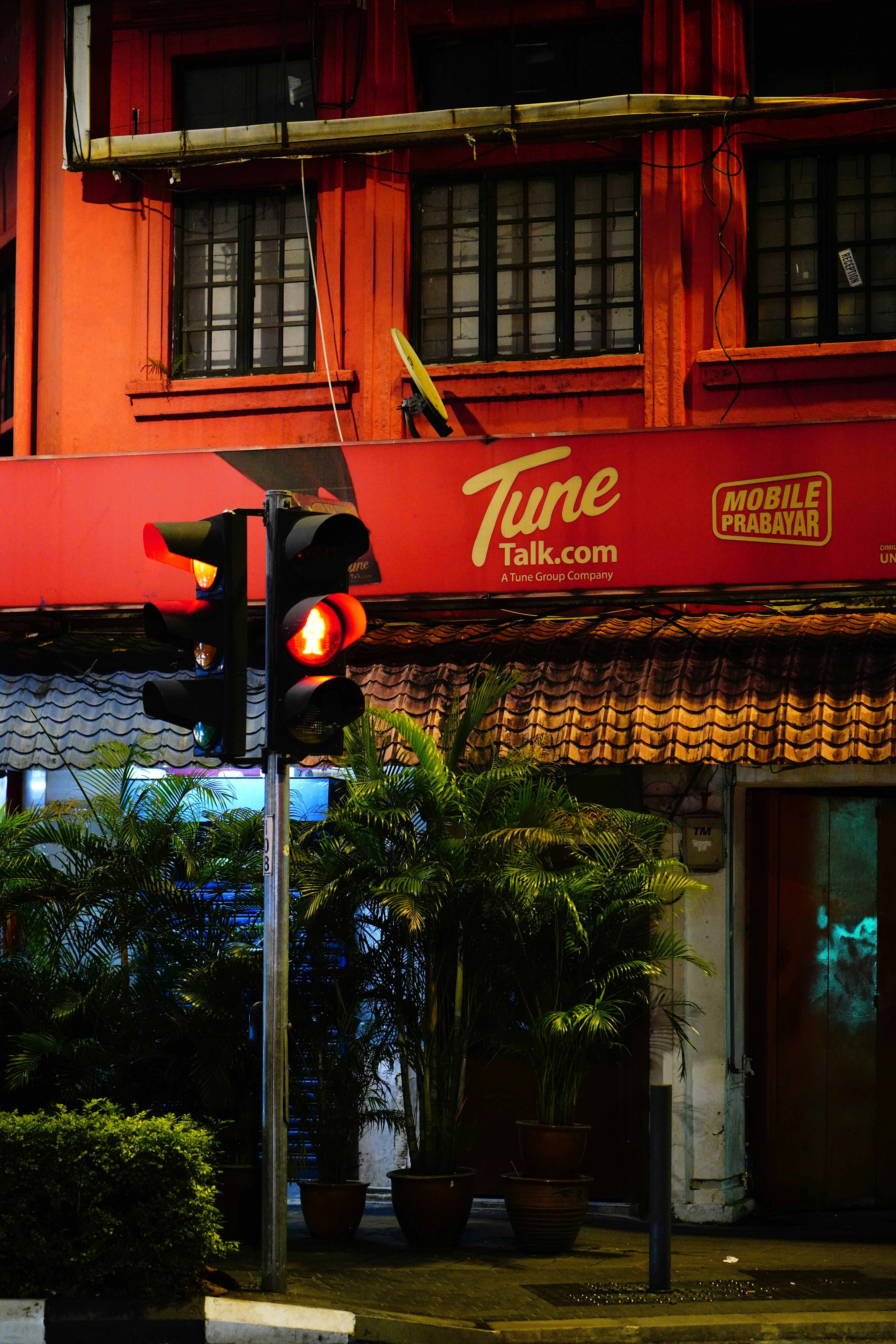 Des lumières rouges éclairent un bâtiment la nuit.