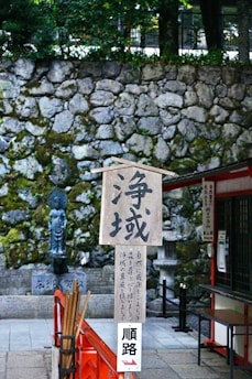A sign and stone wall in japan.
